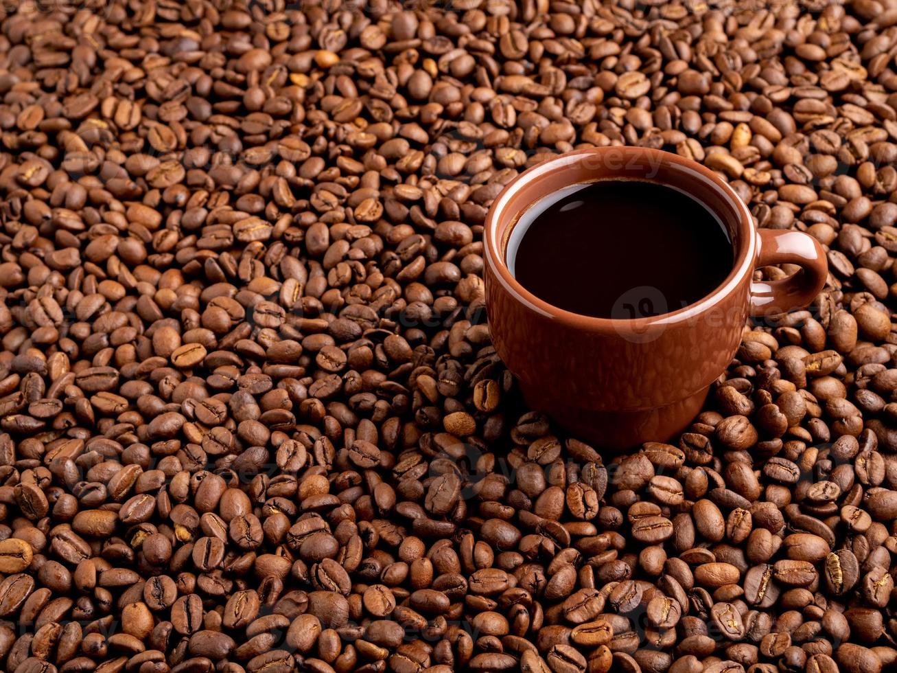 marrone tazza di caffè espresso su sfondo di chicchi di caffè sparsi, vista laterale, copia spazio foto