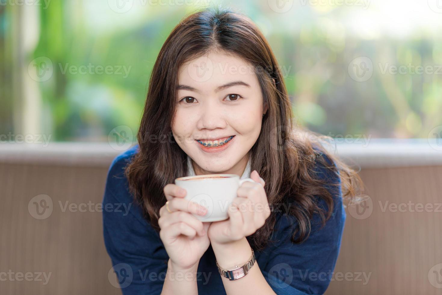 caffè bevente sorridente asiatico felice della studentessa foto
