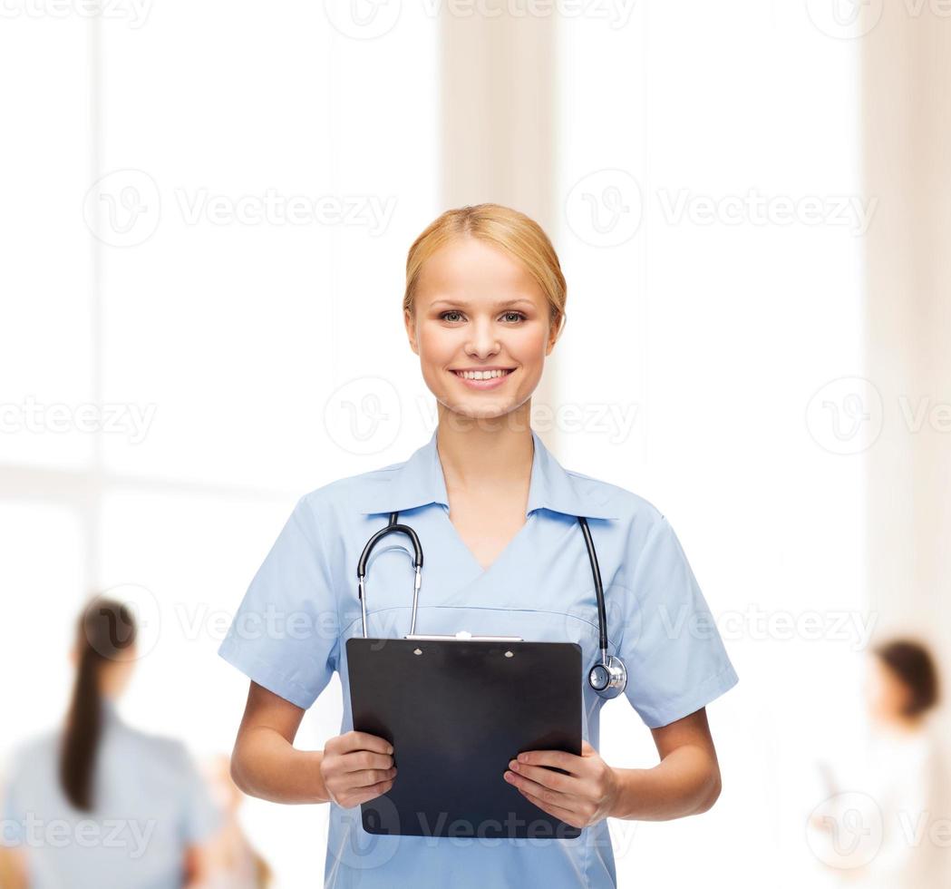 sorridente femmina medico o l'infermiere con appunti foto