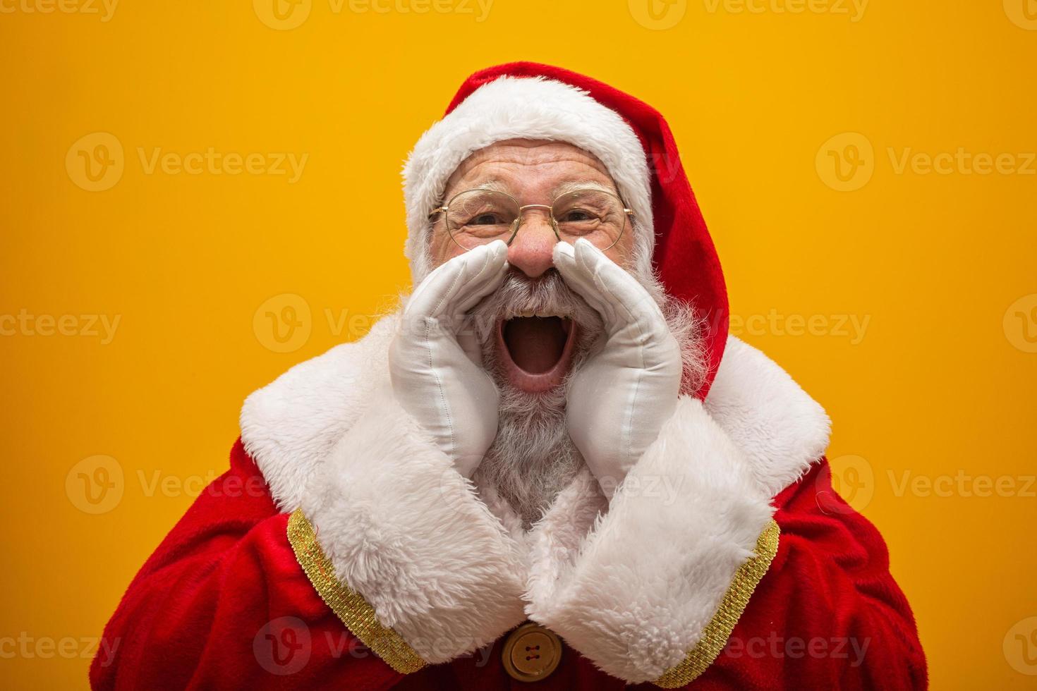 concetto di comunicazione. profilo vista laterale foto di eccitato divertente tipo elegante babbo natale con la bocca aperta tenere il palmo della mano vicino al viso dicendo forte ho-ho-ho isolato su sfondo giallo vivido