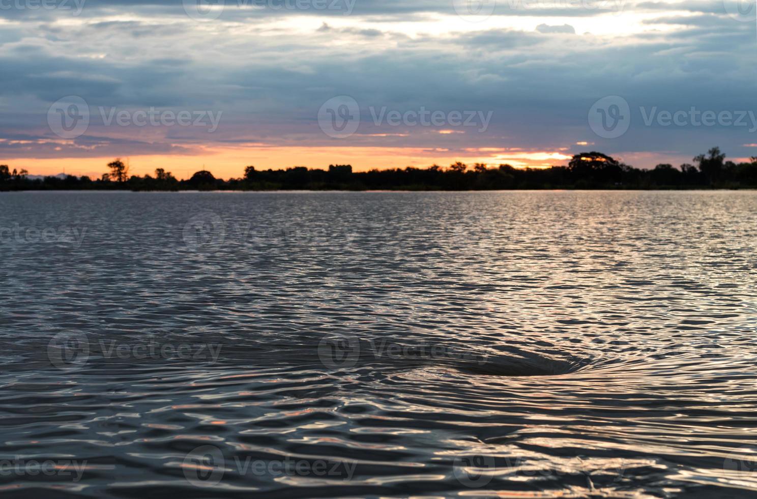 il sole arancione si illumina con le onde dell'acqua. foto