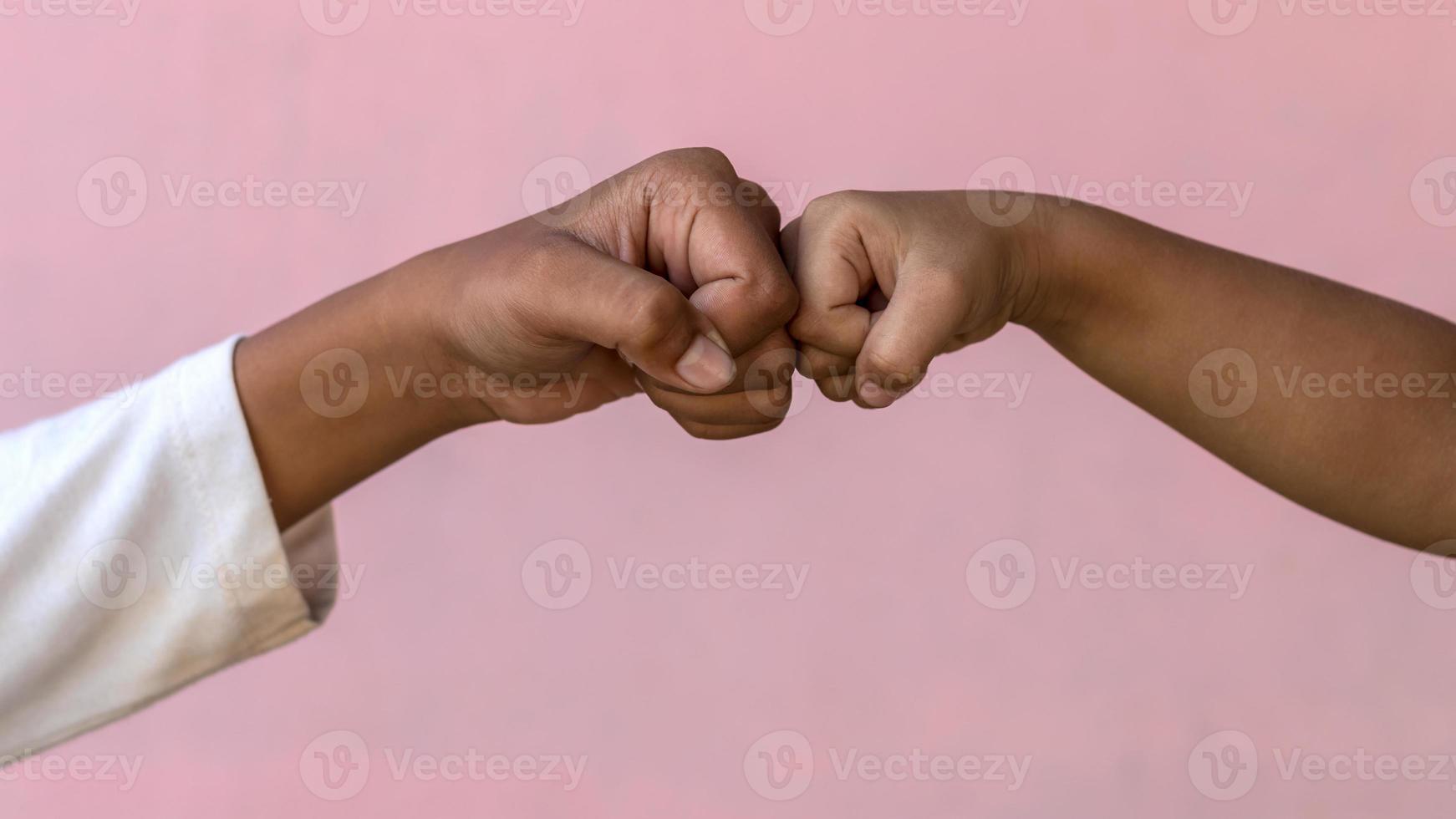 entrambe le mani si danno un pugno contro il muro rosa. foto