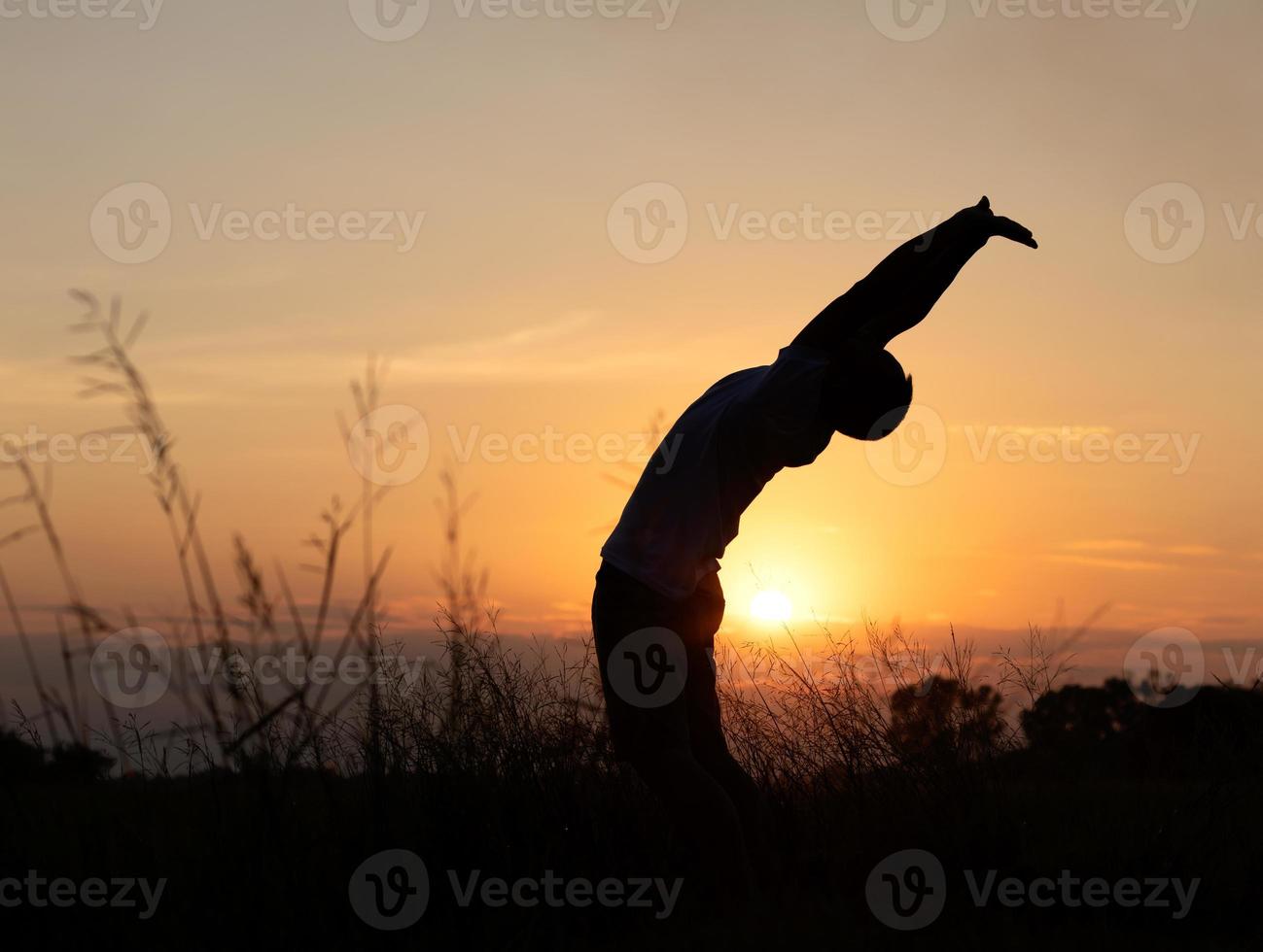 sagoma del tramonto con la schiena dell'uomo che allunga il corpo. foto