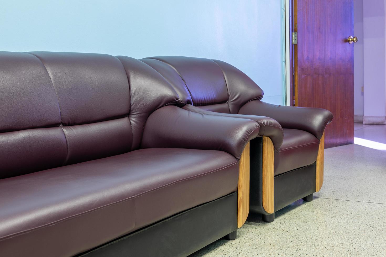 due divani chaise long marroni nella stanza con pareti blu e porte in legno. foto
