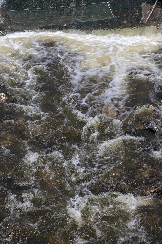 l'acqua scorre violentemente con una nassa. foto