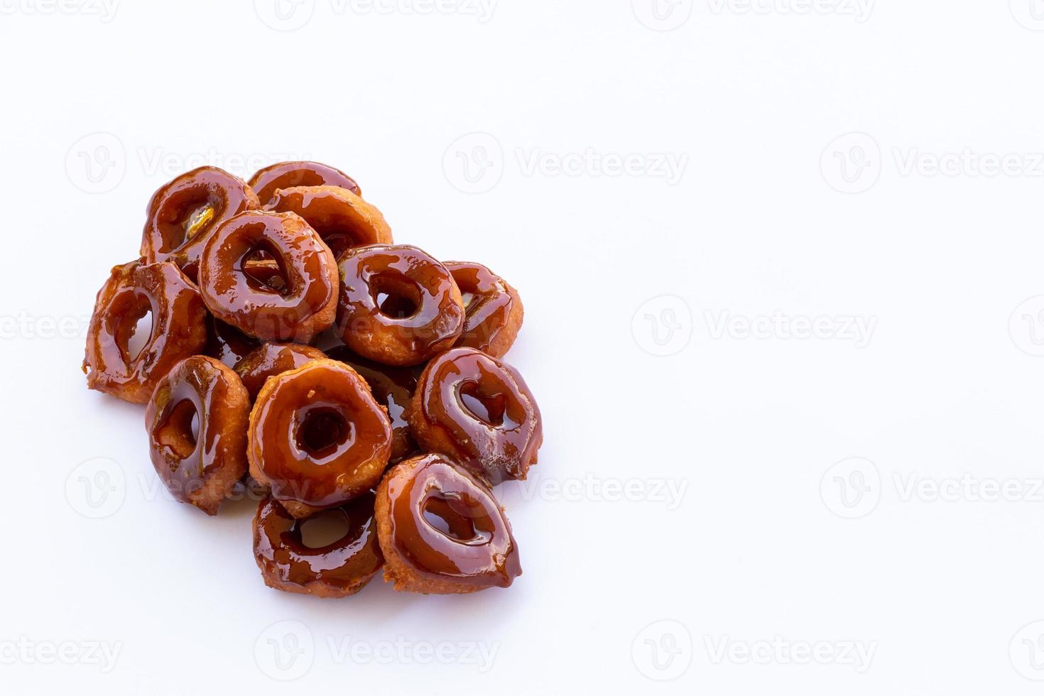 un mucchio di ciambelle tailandesi fritte ricoperte di zucchero bruciato su sfondo bianco. foto