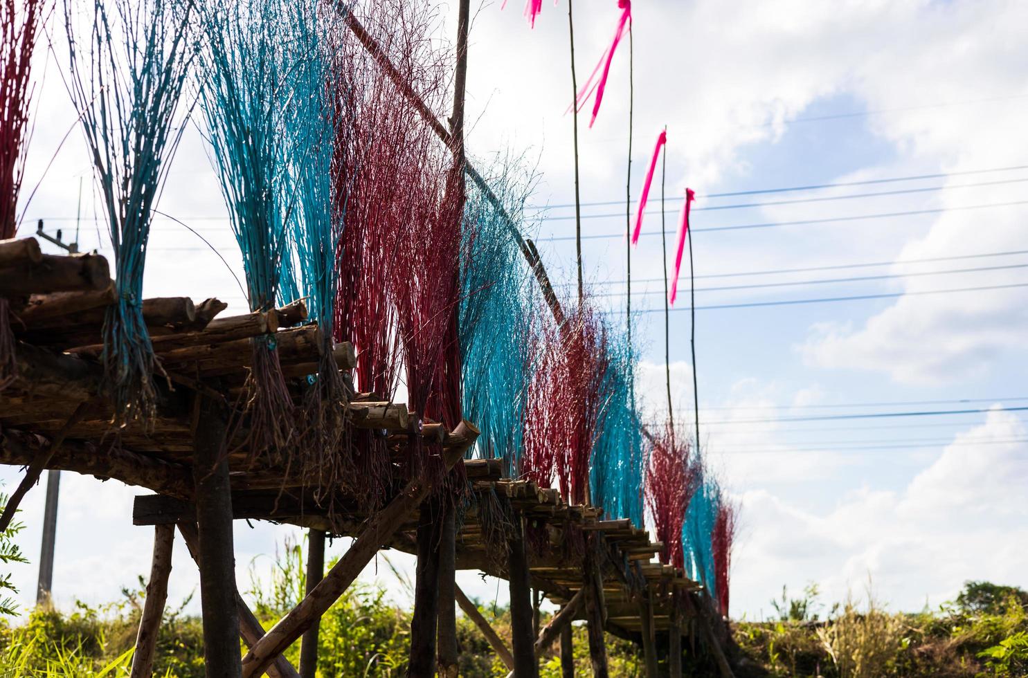 una vista ravvicinata di un ponte di tronchi di eucalipto decorato con ramoscelli dai colori vivaci. foto