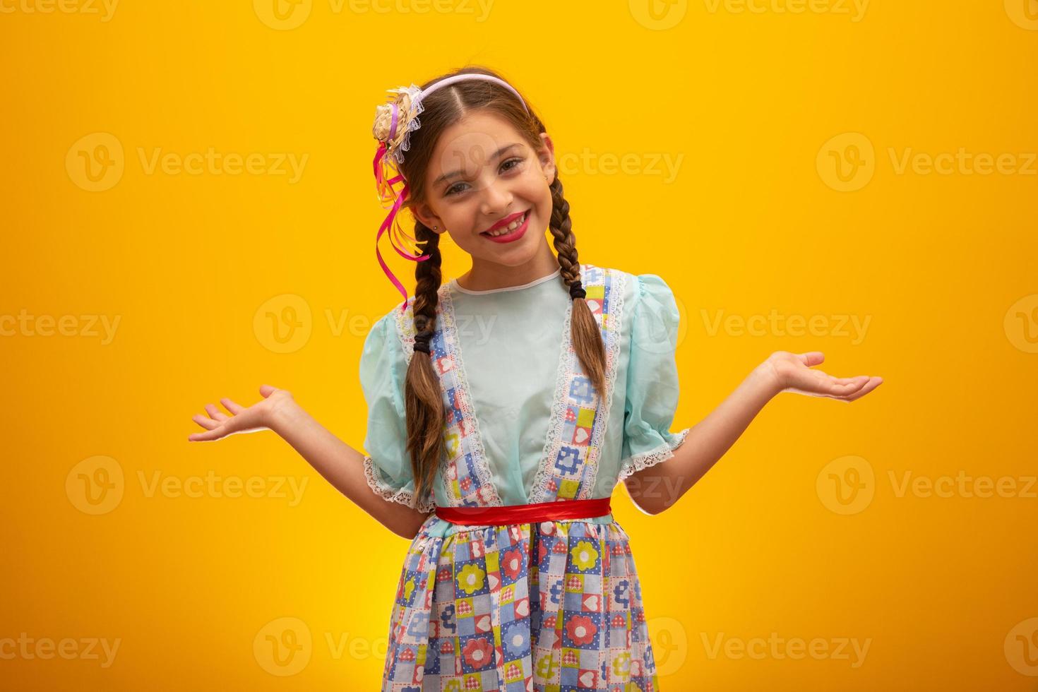 bambino in abiti tipici della famosa festa brasiliana chiamata festa junina nella celebrazione di sao joao. bella ragazza su sfondo giallo. foto