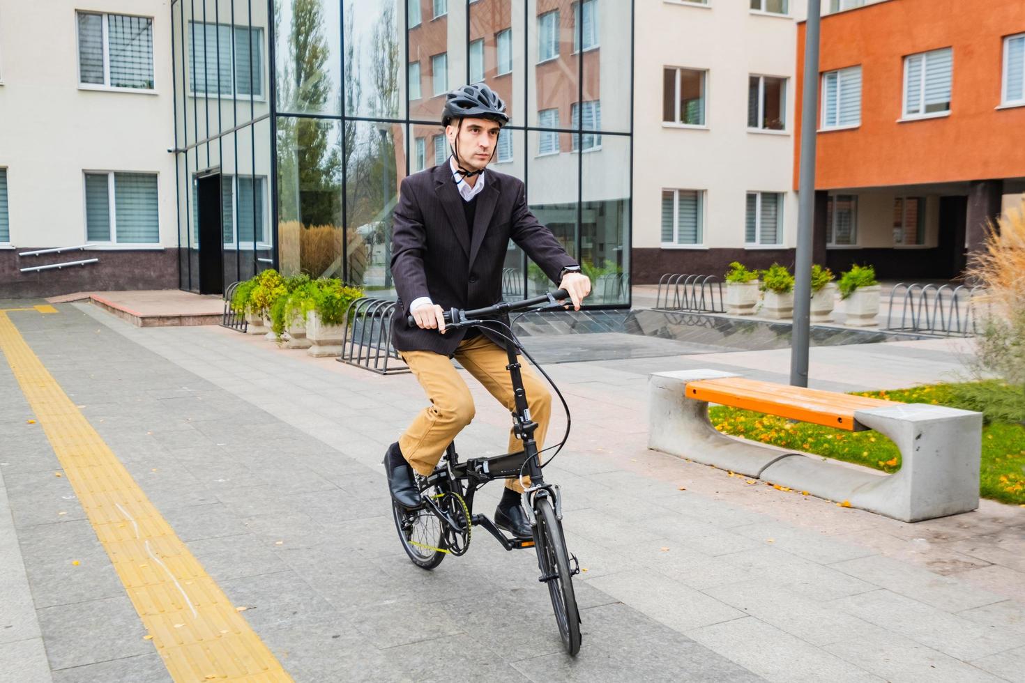 giovane uomo d'affari maschio con bicicletta e tazza di caffè o tè che cammina all'aperto foto