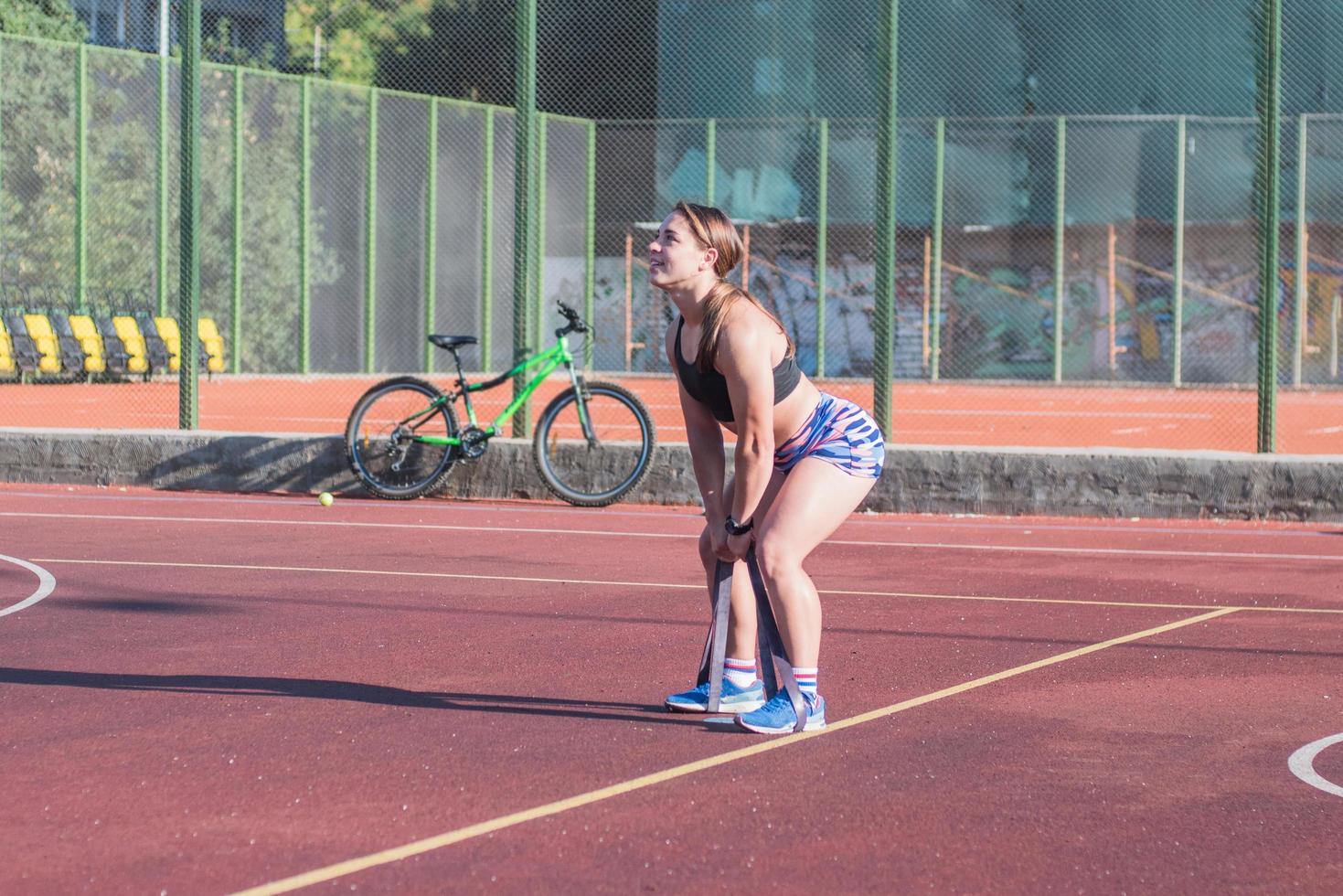 giovane donna forte che si allena all'aperto in estate, l'atleta professionista femminile fa esercizi nel parco foto