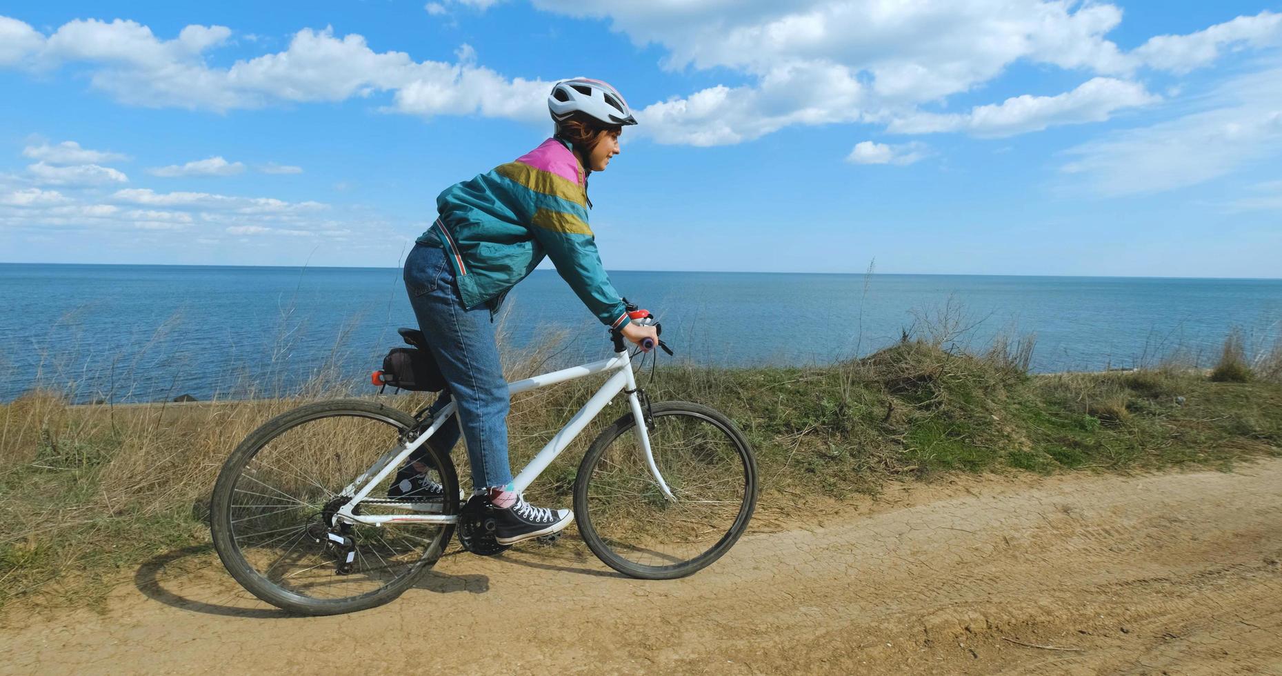 giovane donna ciclista in casco in una soleggiata giornata estiva foto