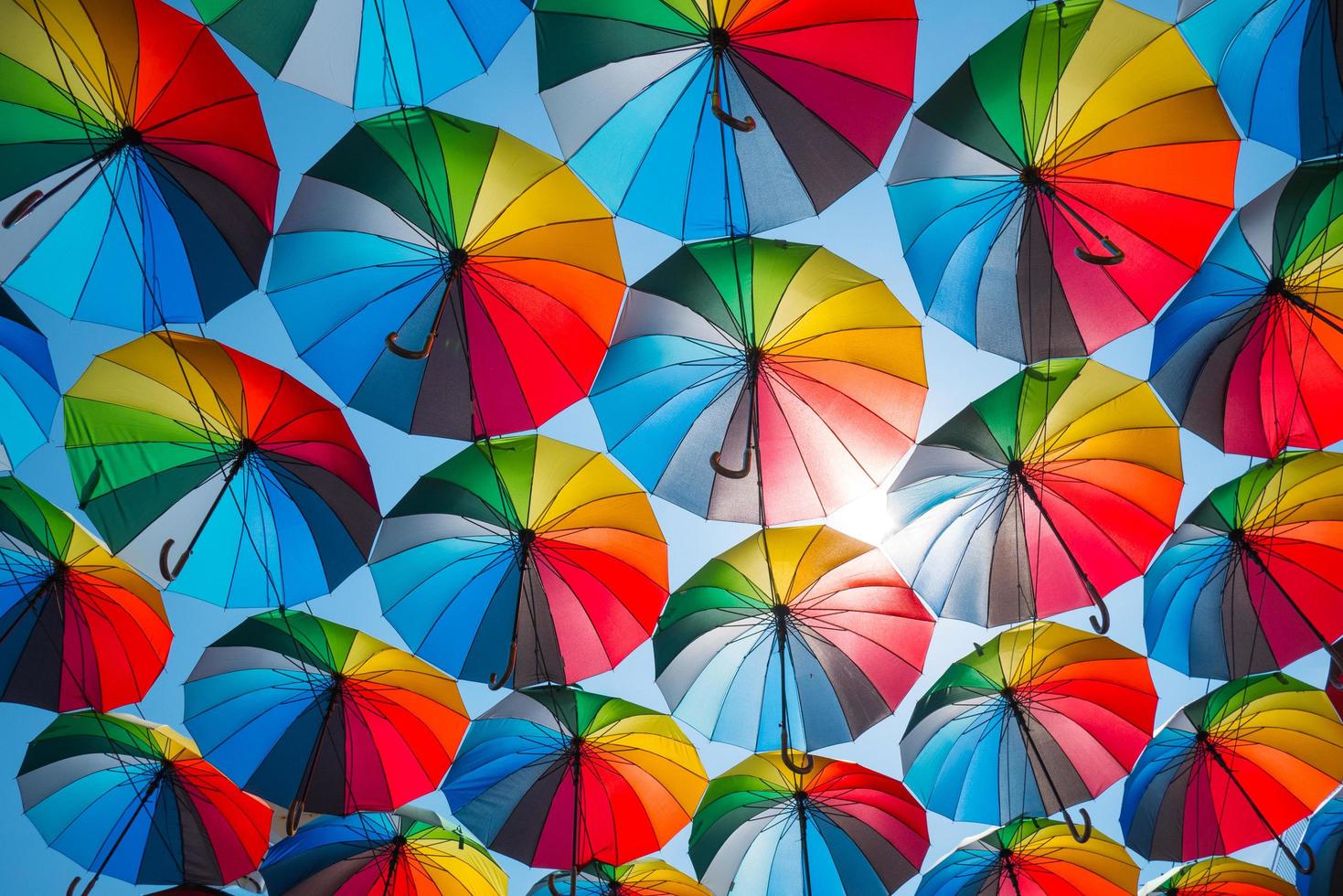 decorazione all'aperto con molti ombrelloni colorati contro il cielo blu e il sole foto