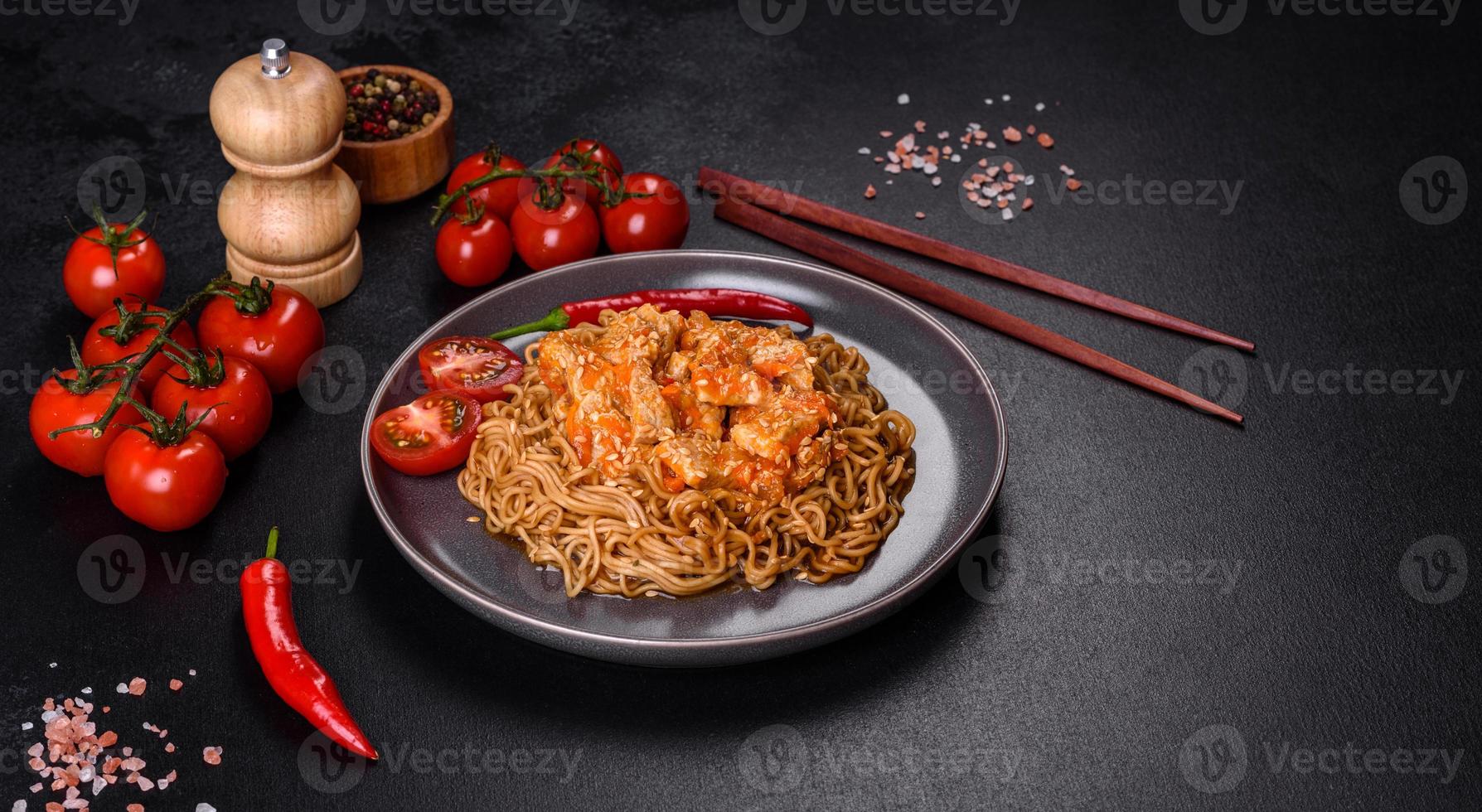 noodle tailandese e piatto di pollo su uno sfondo di cemento nero con bacchette cinesi e spazio per la copia foto