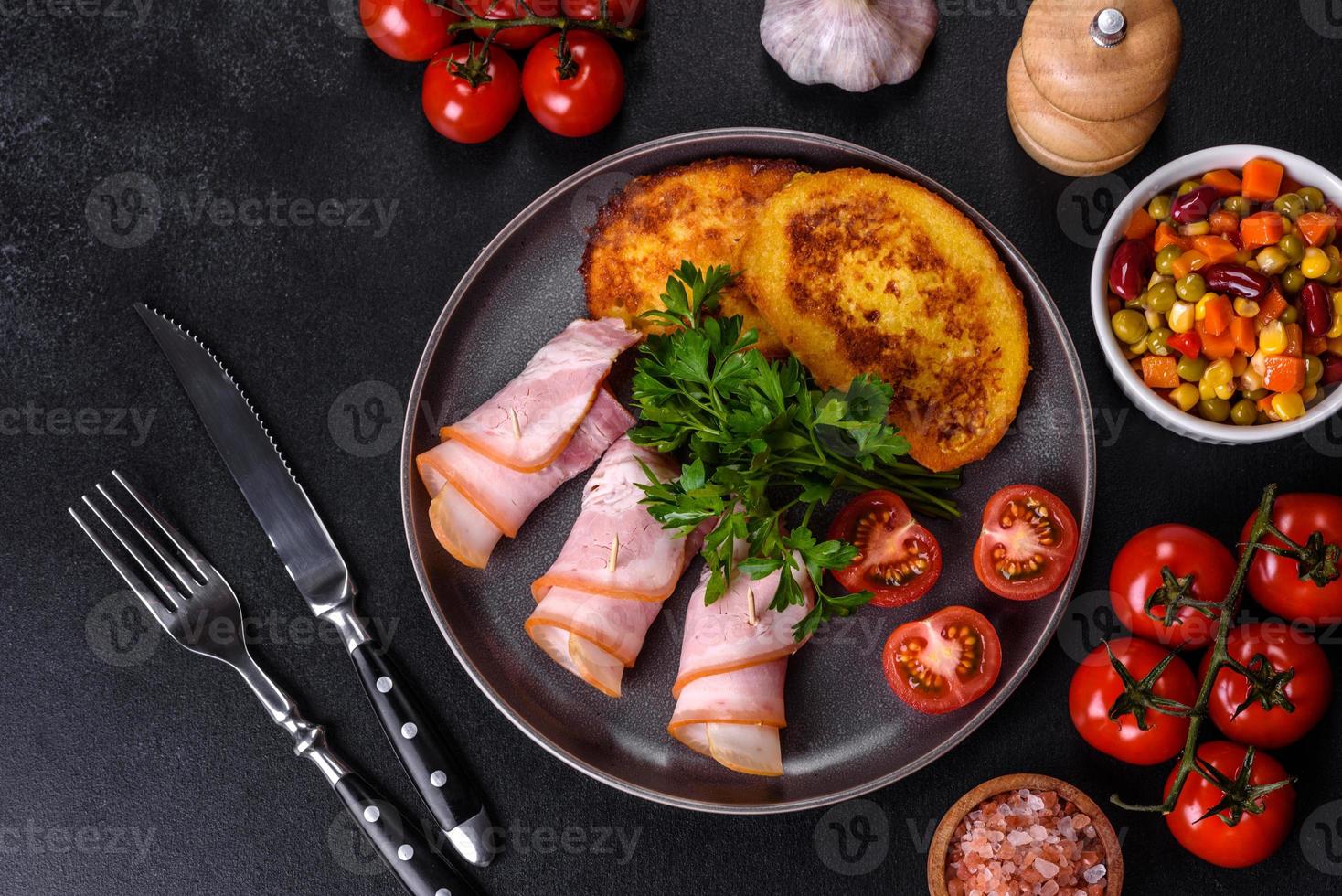 fette di deliziosa pancetta cruda o salata con spezie, sale, verdure ed erbe aromatiche su un tagliere di legno foto