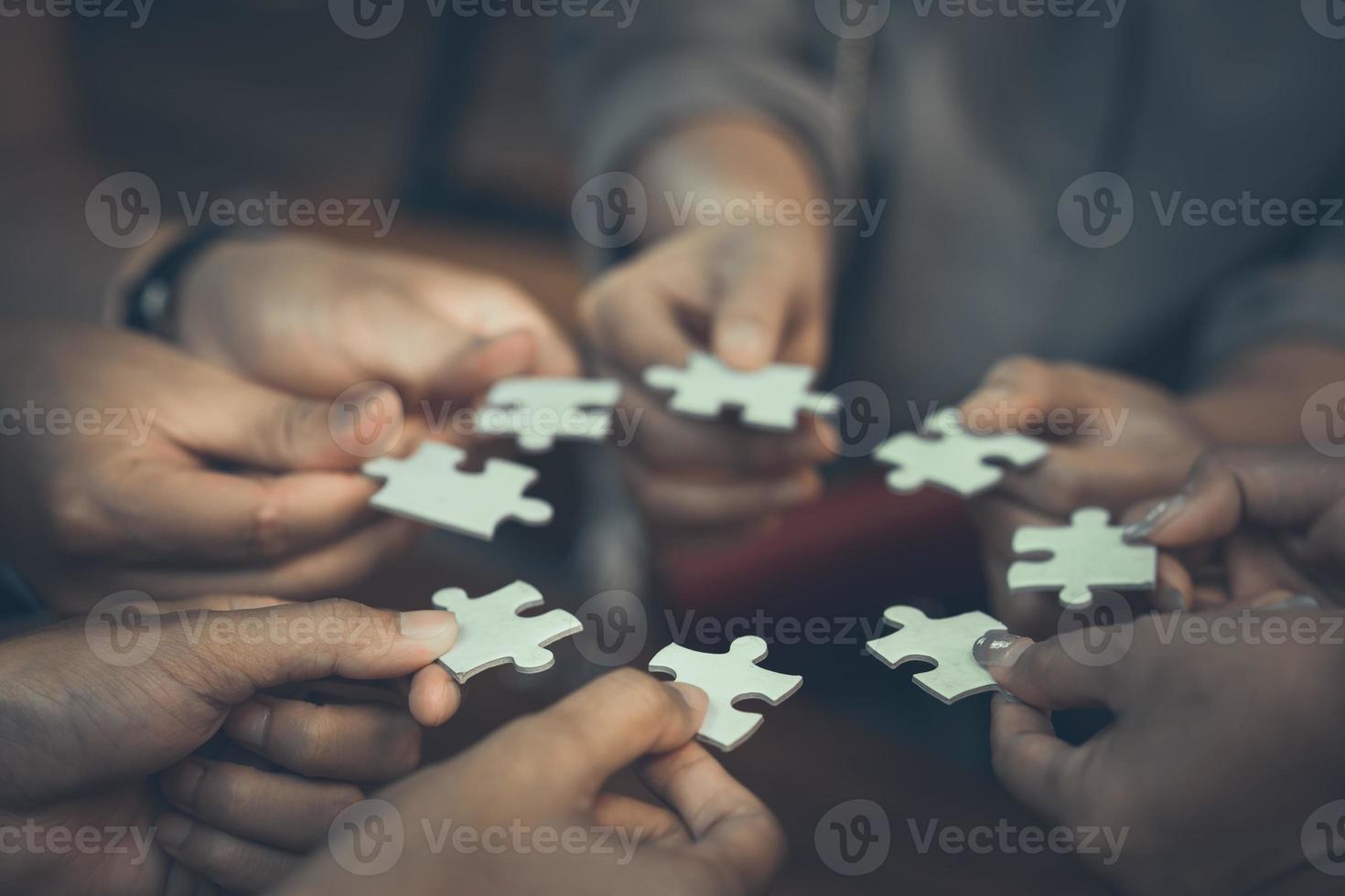 squadra che mette insieme quattro puzzle per il concetto di squadra foto