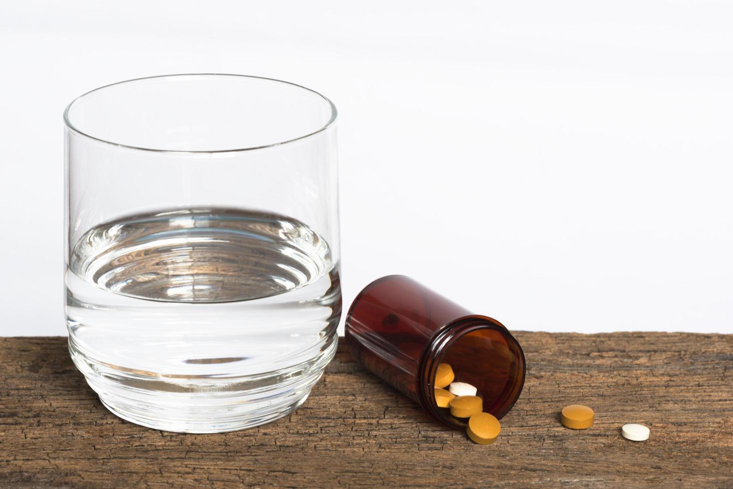 farmaci e un bicchiere d'acqua foto
