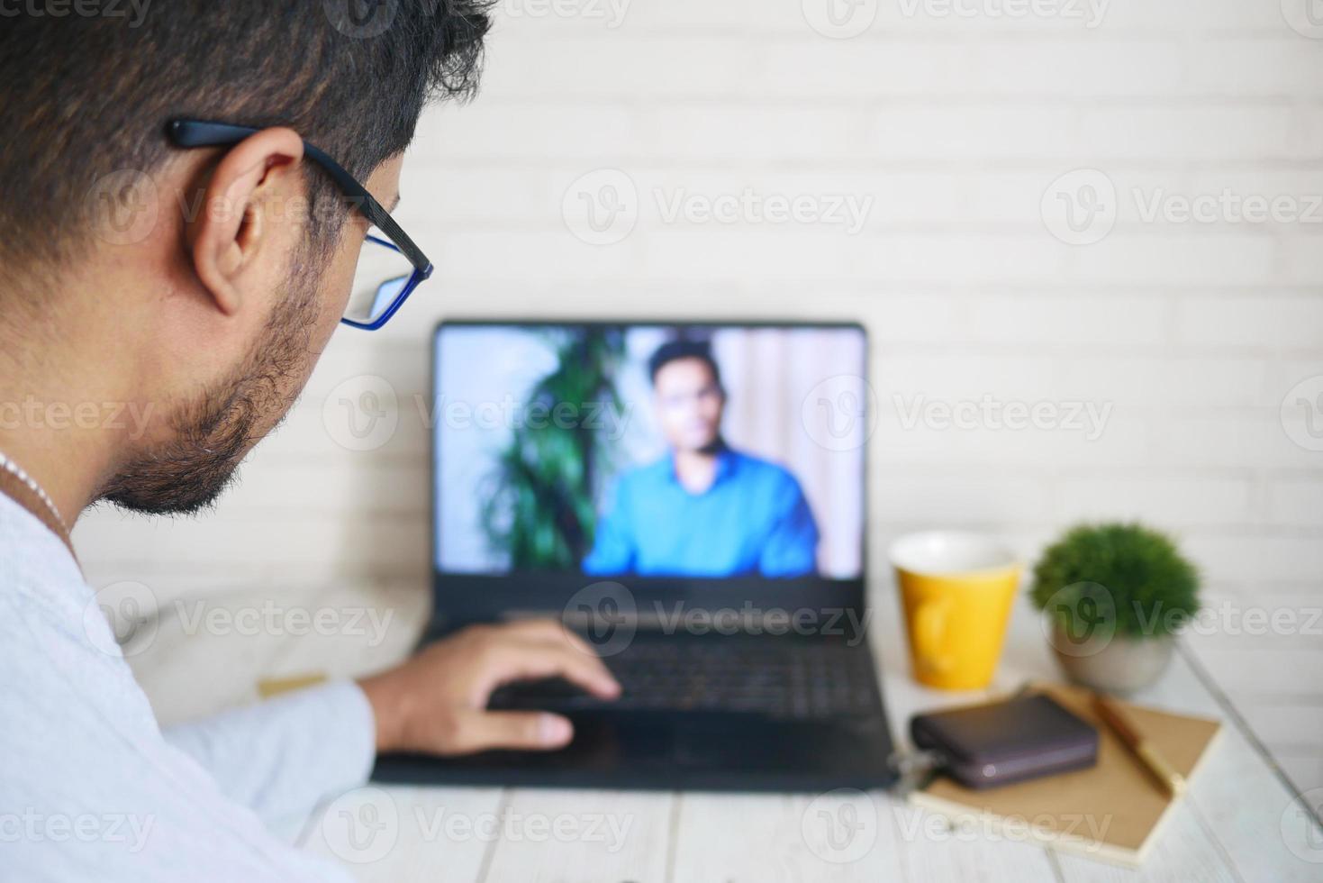 vista posteriore dell'uomo d'affari in videoconferenza per discutere di strategia foto