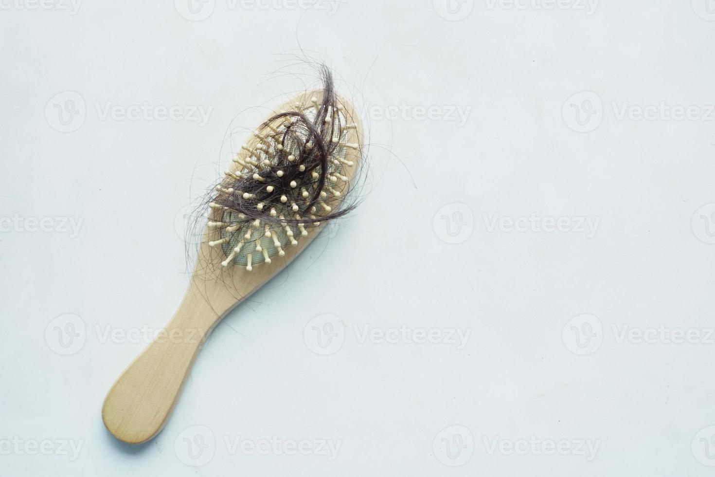 una spazzola con i capelli persi sul tavolo foto