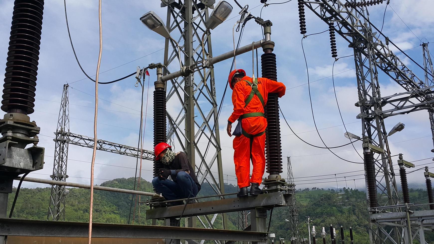 l'elettricista in rosso sta facendo riparazioni periodiche foto