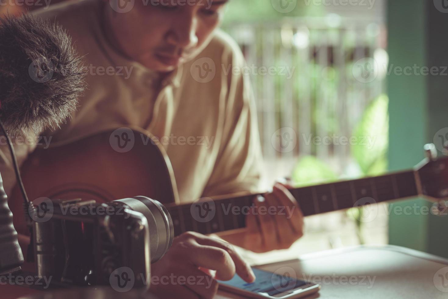 giovane uomo asiatico che suona la chitarra rilassante in un caffè. foto