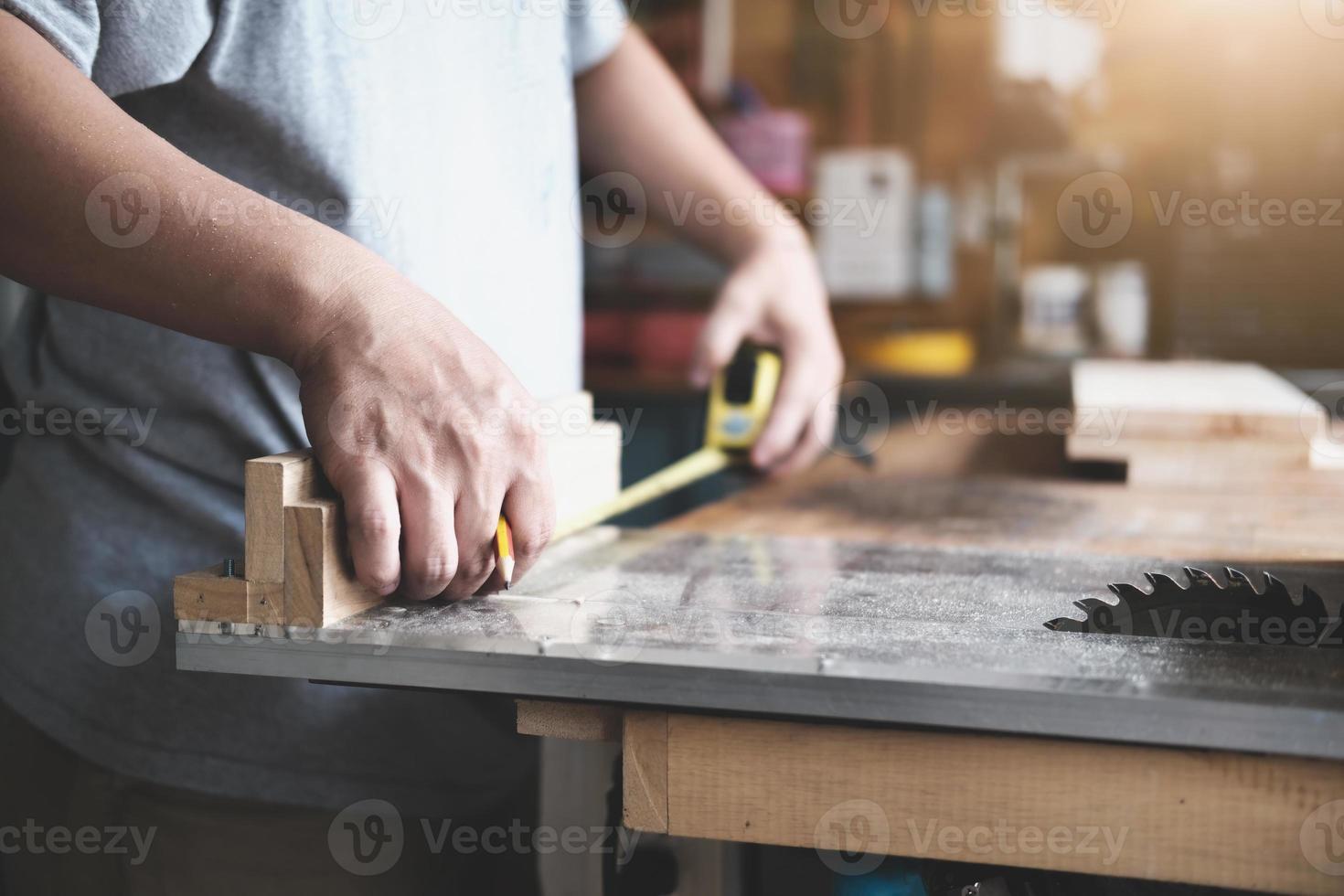 Gli artigiani del concetto fai-da-te utilizzano un metro a nastro per assemblare pezzi di legno per realizzare tavoli in legno per i clienti. foto