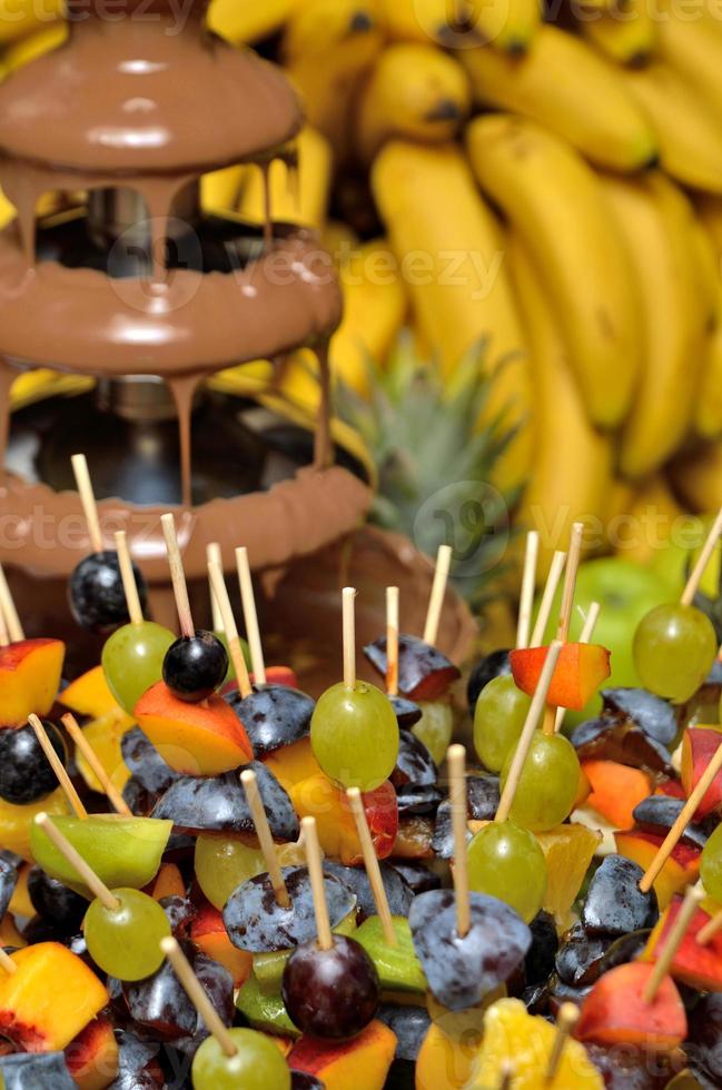 fontana di cioccolato con spiedini di frutta foto