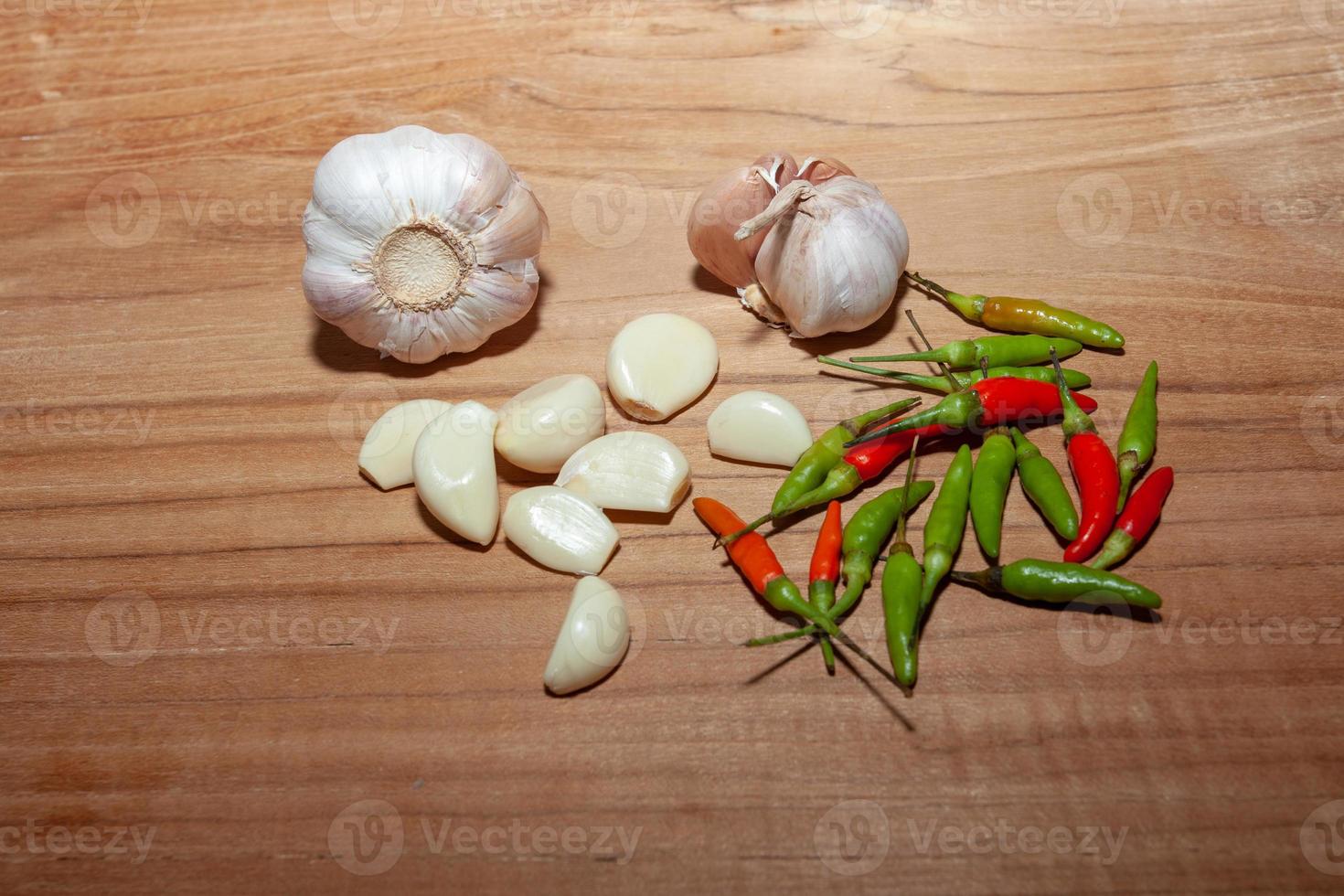 aglio bianco e peperoncino sul pavimento di legno per cucinare foto