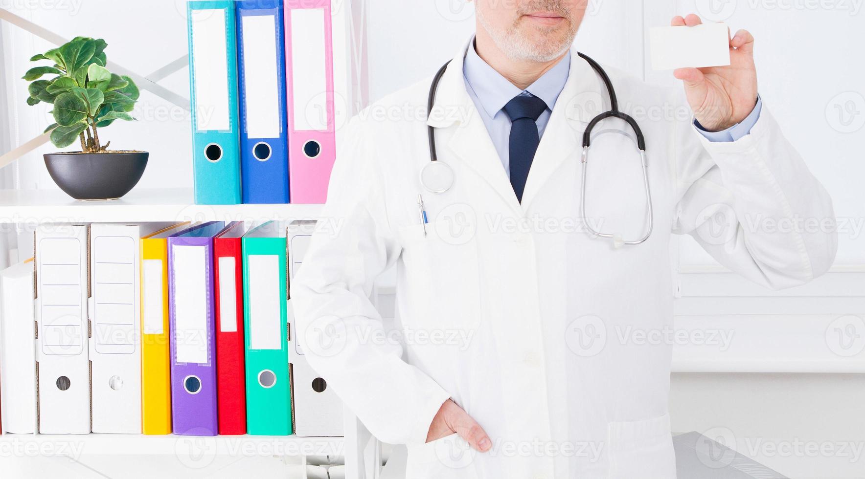 medico che mostra il suo biglietto da visita, concetto medico, assicurazione medica, uomo in uniforme bianca. copia spazio foto
