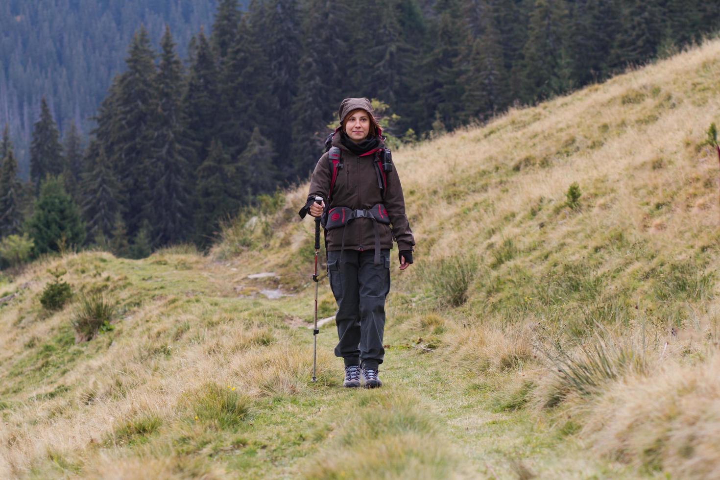 giovane donna escursionista nella foresta d'autunno foto