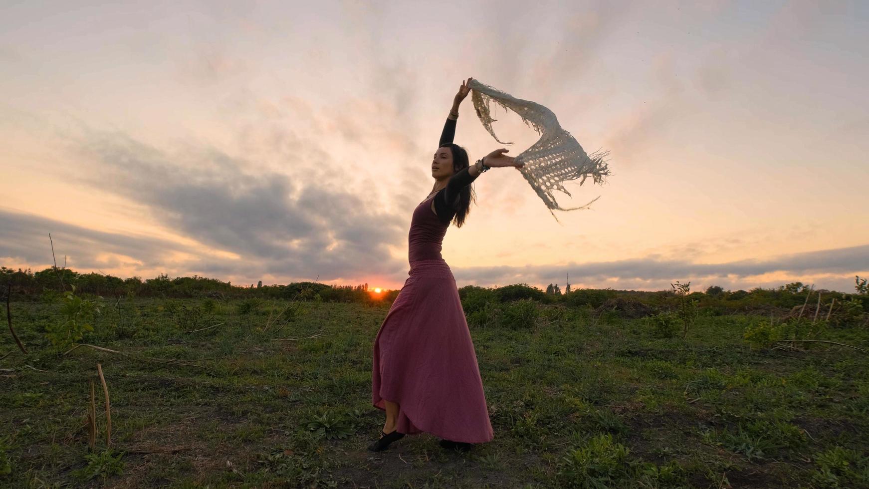 felice danza femminile nei campi estivi durante il bel tramonto foto