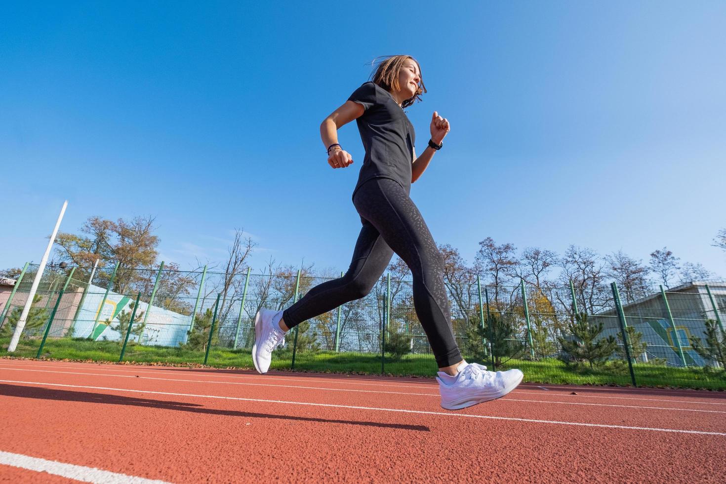 giovane corridore femminile che si allena in una giornata estiva all'aperto sullo studium foto