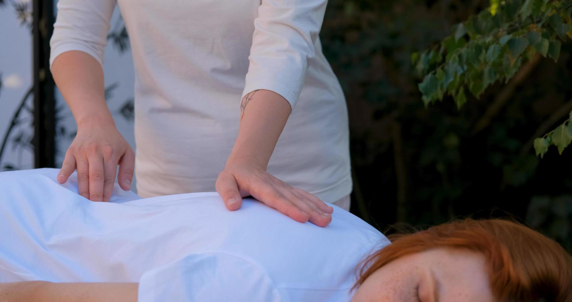 la donna fa il massaggio cinese tradizionale all'aperto nel giardino estivo foto