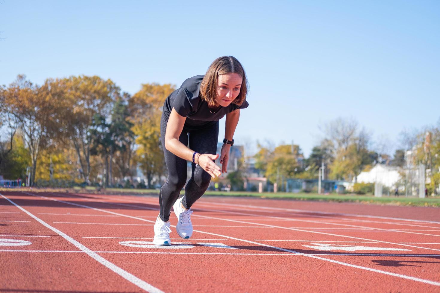 giovane corridore femminile che si allena in una giornata estiva all'aperto sullo studium foto