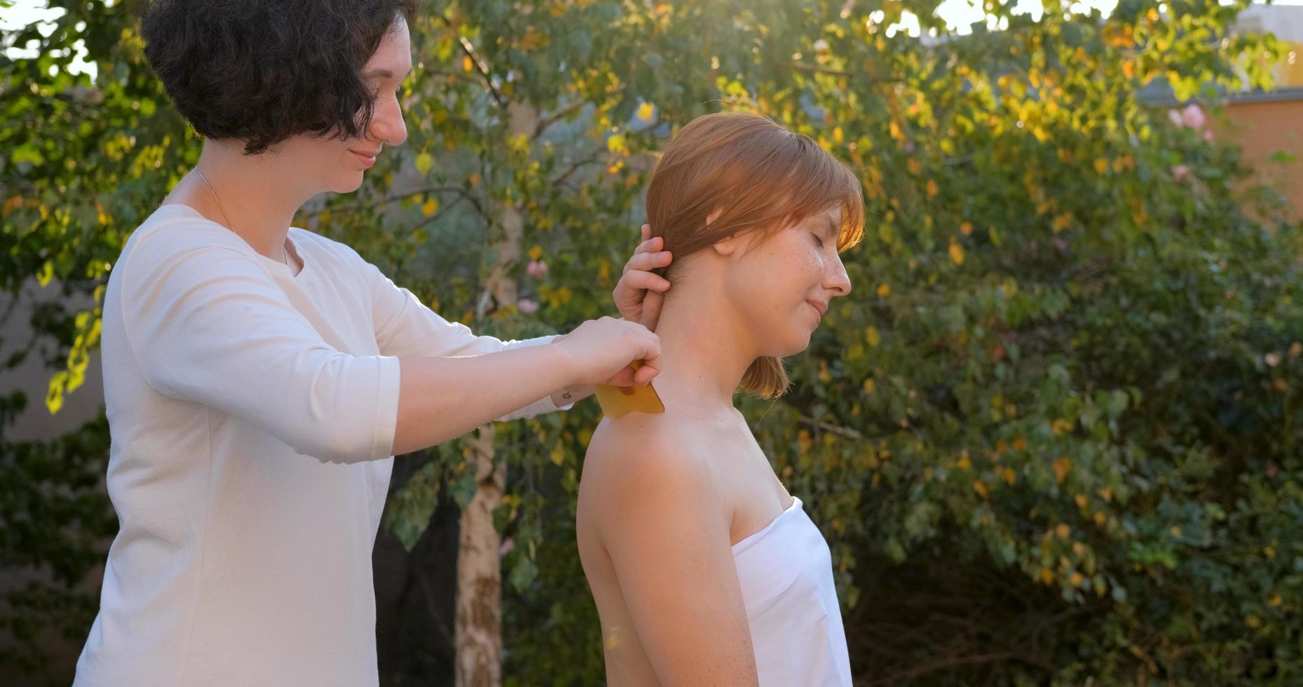 la donna fa il massaggio cinese tradizionale all'aperto nel giardino estivo foto