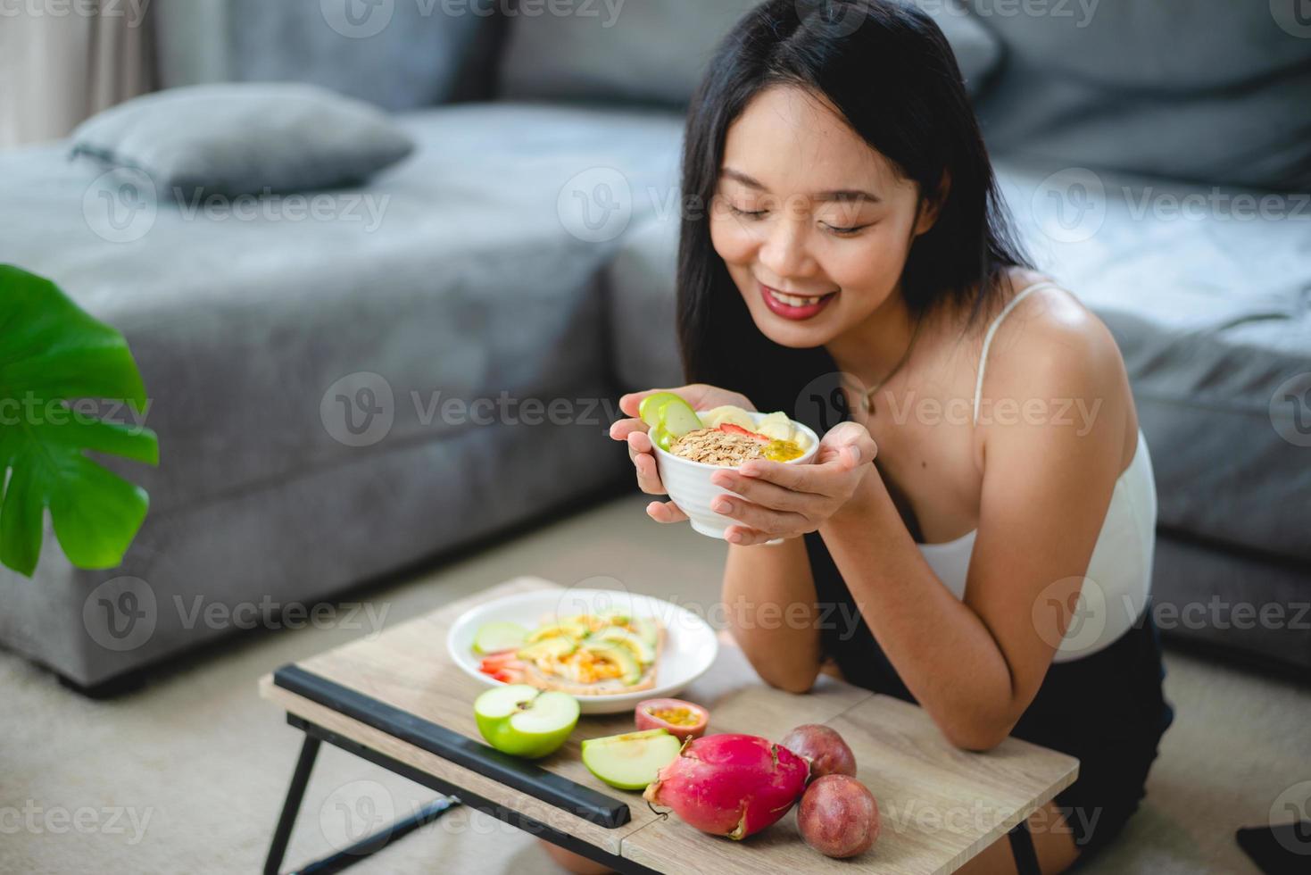 giovane donna asiatica ragazza che tiene cibo salutare verdura fresca nello stile di vita a casa, femmina bella persona vegetariana che fa dieta nutrimento mangiare insalata, le persone sono sorridenti, concetto di cibo sano foto