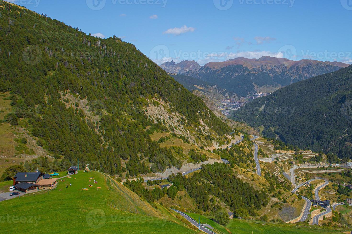 vista di una strada sinuosa in montagna e un bellissimo paesaggio durante una soleggiata giornata primaverile ad andorra foto