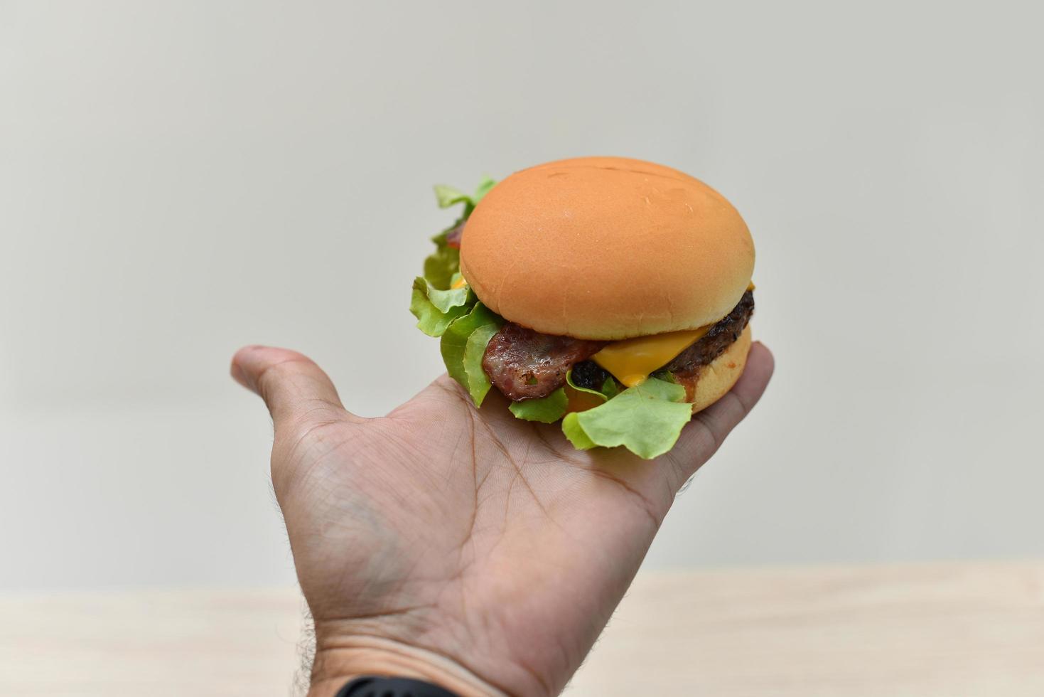 mano che tiene hamburger hamburger a portata di mano foto
