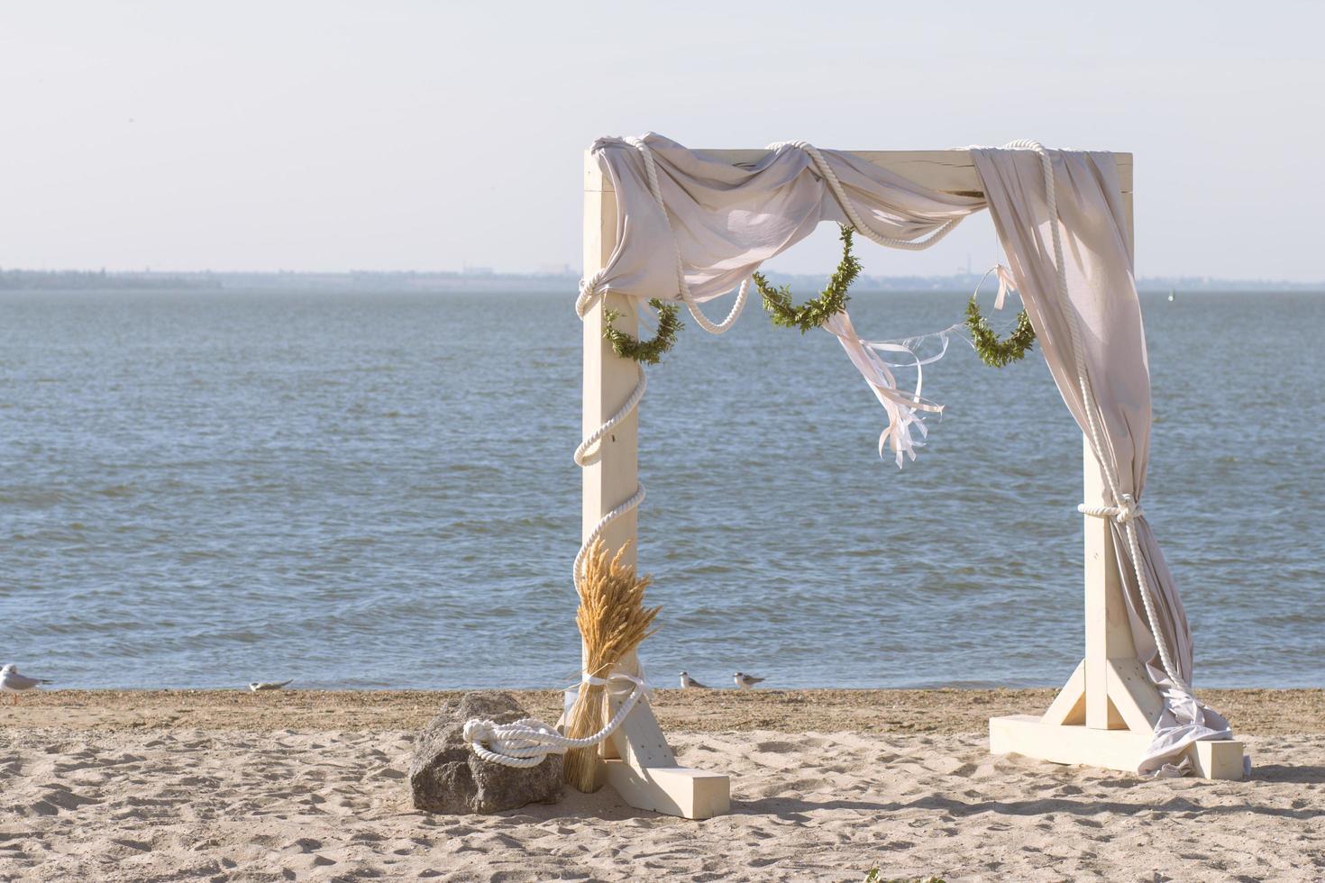 impostazione di cerimonia nuziale in legno sulla spiaggia foto