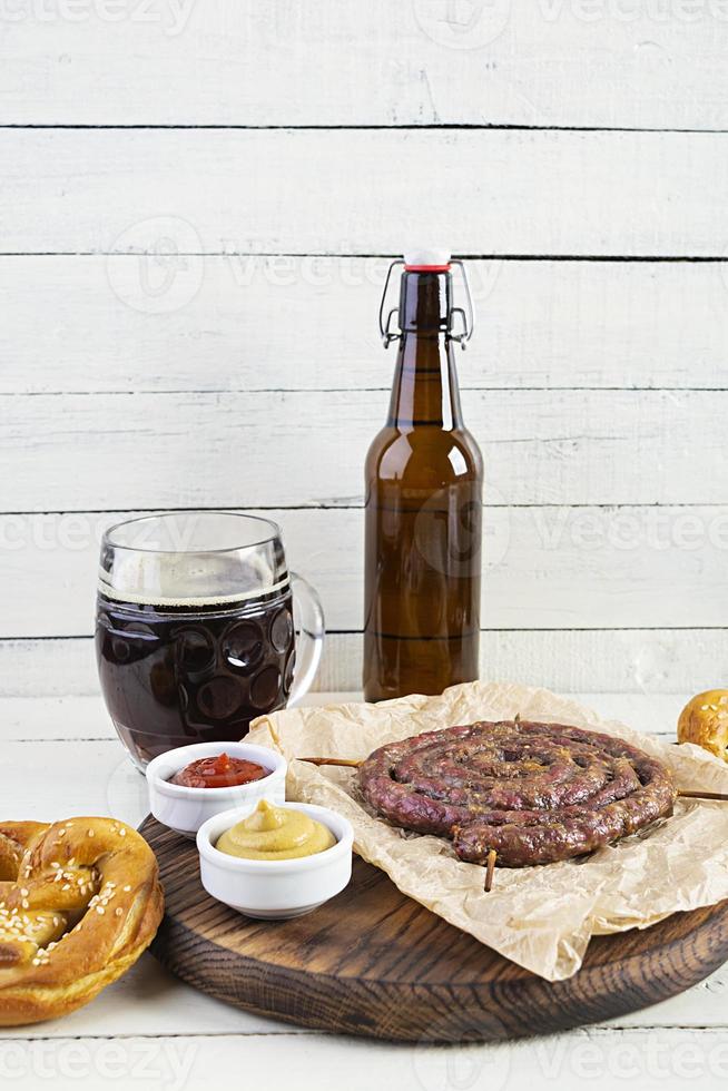 menu del cibo per l'oktoberfest. salsiccia con salsa diversa, pretzel e bicchiere di birra scura foto