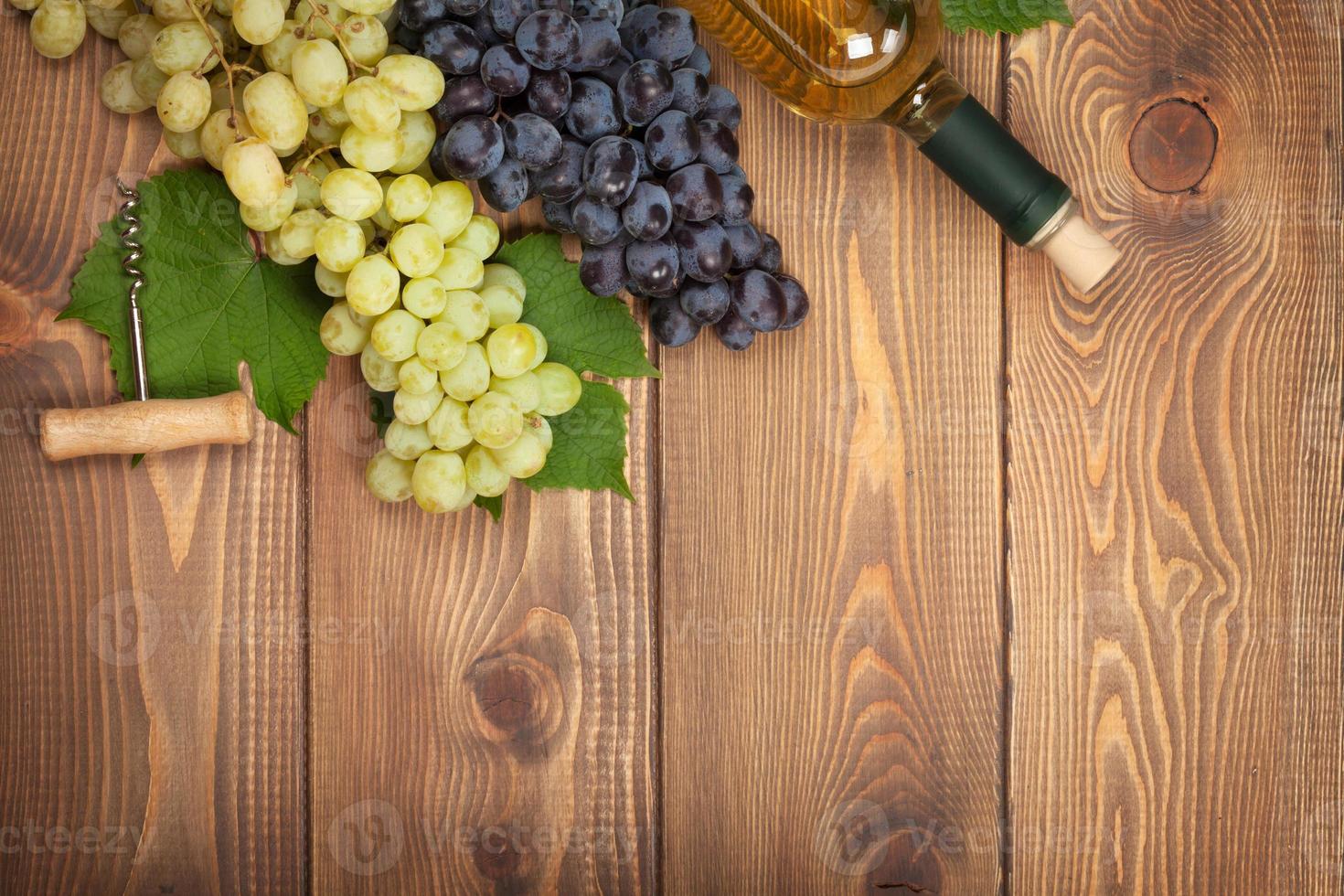 bottiglia di vino bianco e grappolo d'uva foto