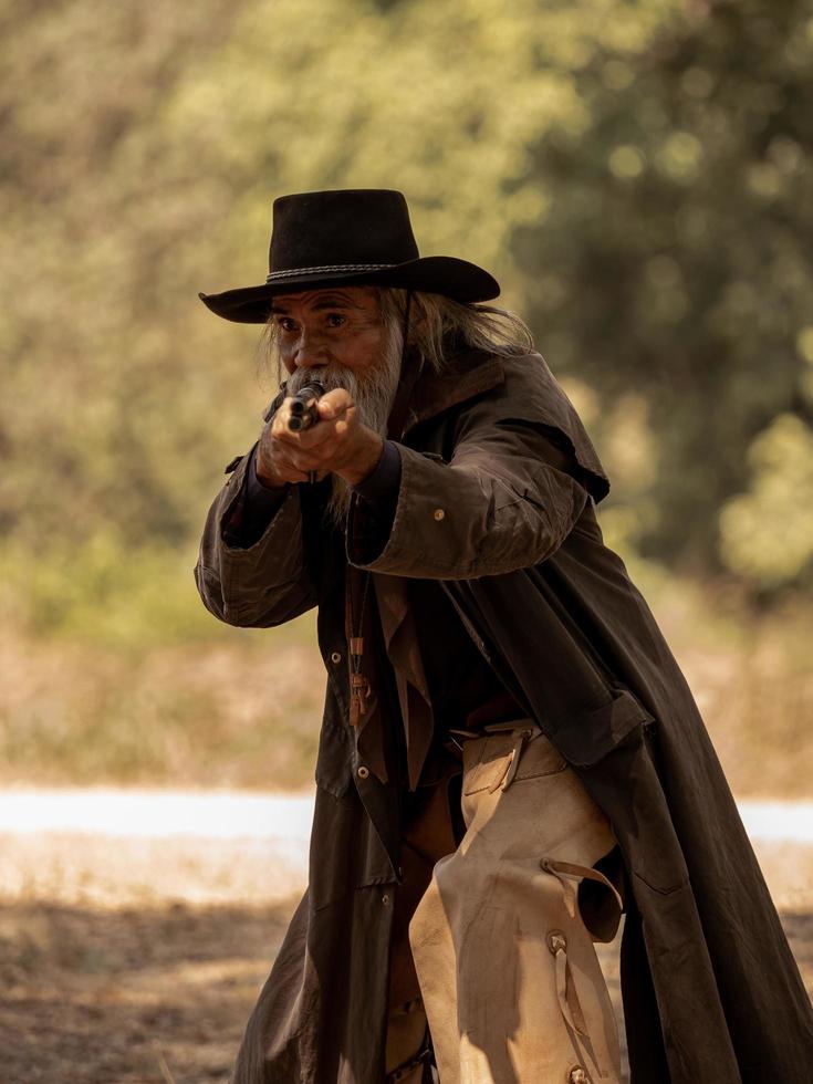 il cowboy anziano ha un lungo fucile di guardia per cercare la sicurezza nell'area rurale dell'azienda agricola foto