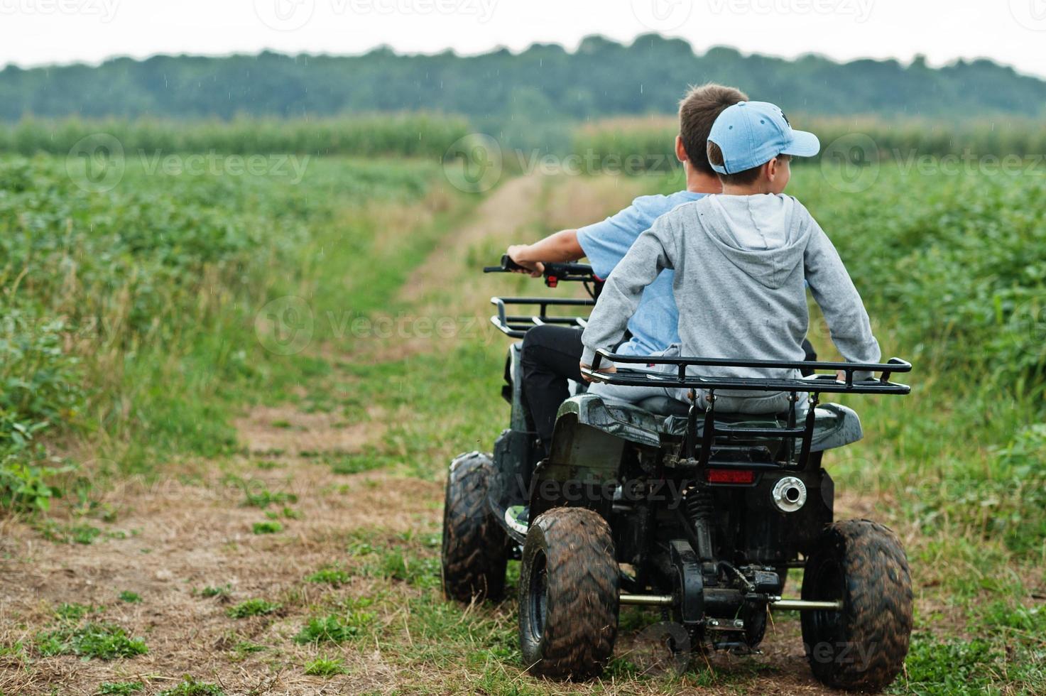 due fratelli che guidano un quad quad a quattro ruote. momenti felici dei bambini. foto