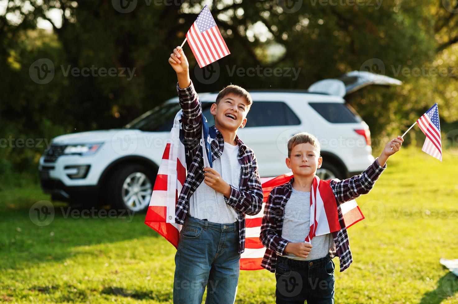 due fratelli con bandiera usa. vacanza in america. orgogliosi di essere figli di campagna. foto