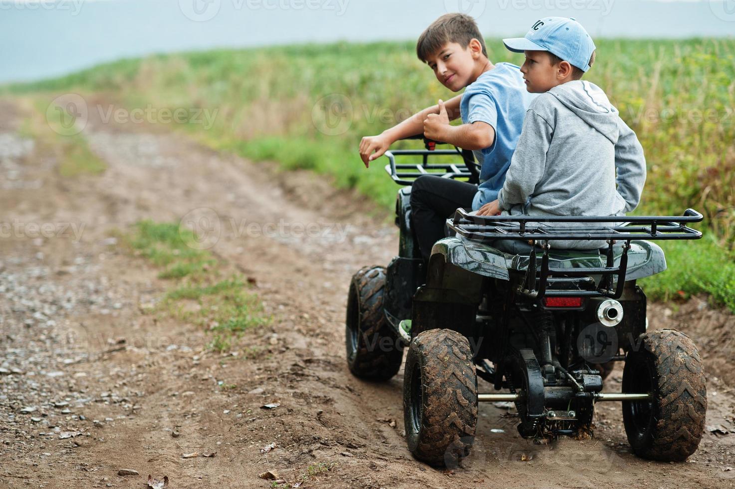 due fratelli che guidano un quad quad a quattro ruote. momenti felici dei bambini. foto