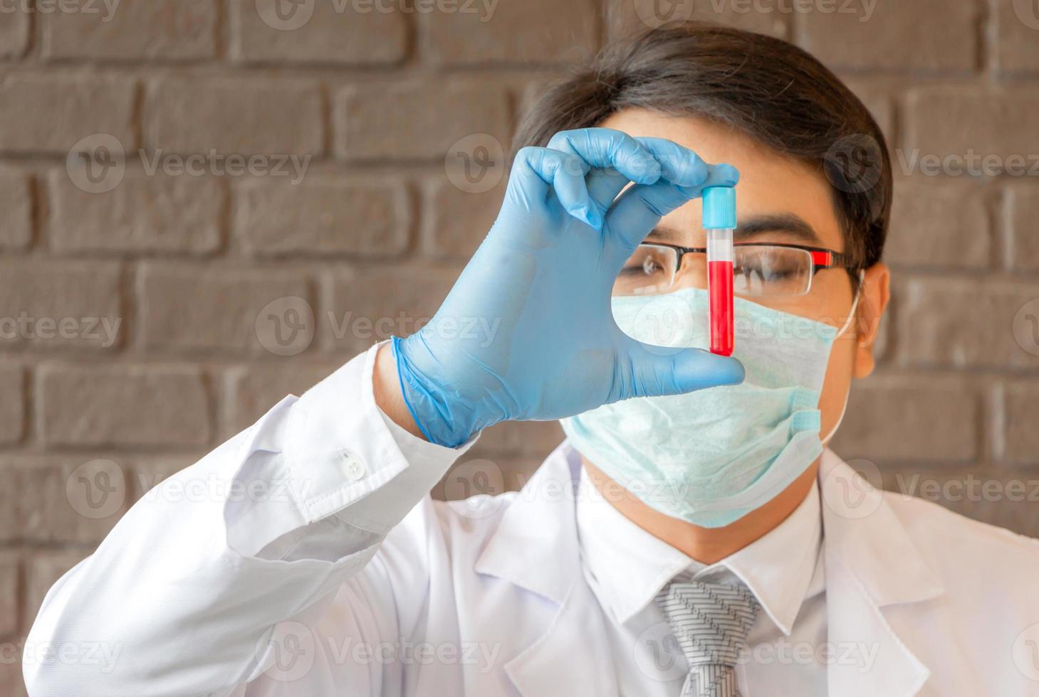 medico che analizza le provette mediche che esaminano il becher con liquido rosso, scienziato che ricerca e apprende in un laboratorio foto