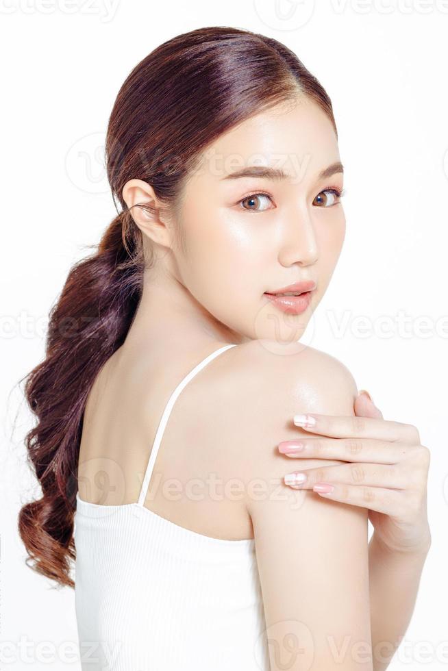 donna asiatica con un bel viso raccolto in una coda di cavallo marrone e pelle pulita e liscia. foto