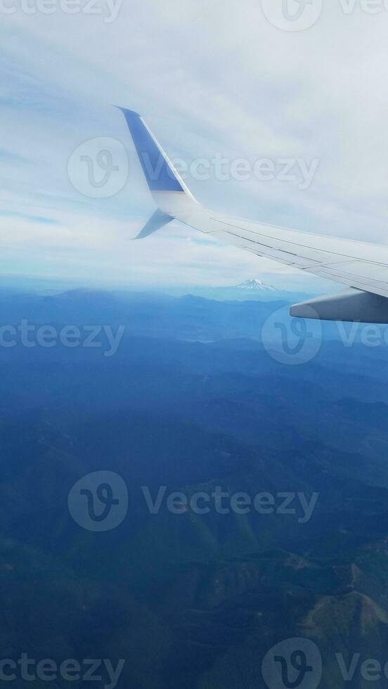 aereo che vola con montagne e paesaggio e nuvole foto