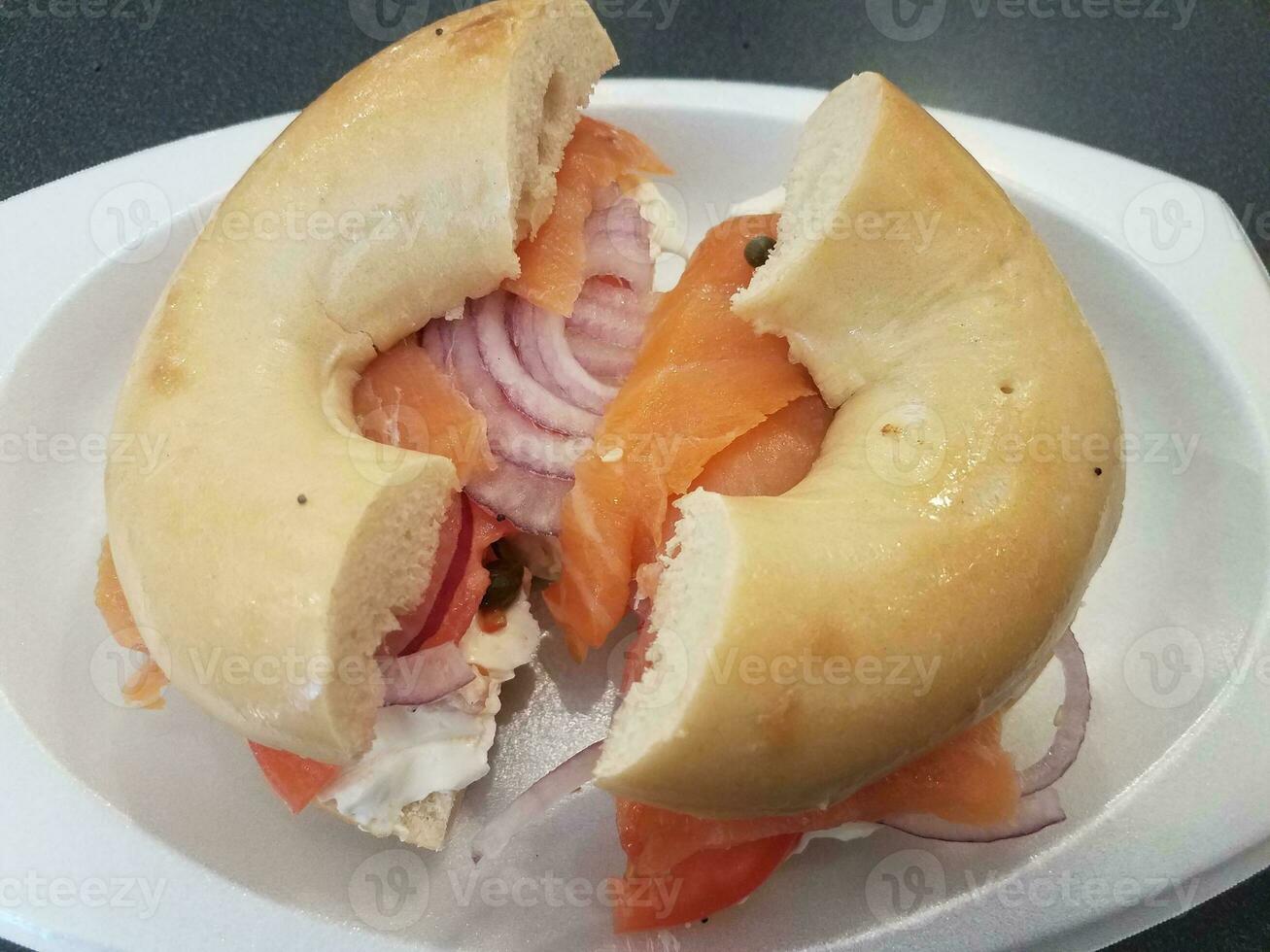 bagel con salmone affumicato, crema di formaggio, cipolla e capperi foto