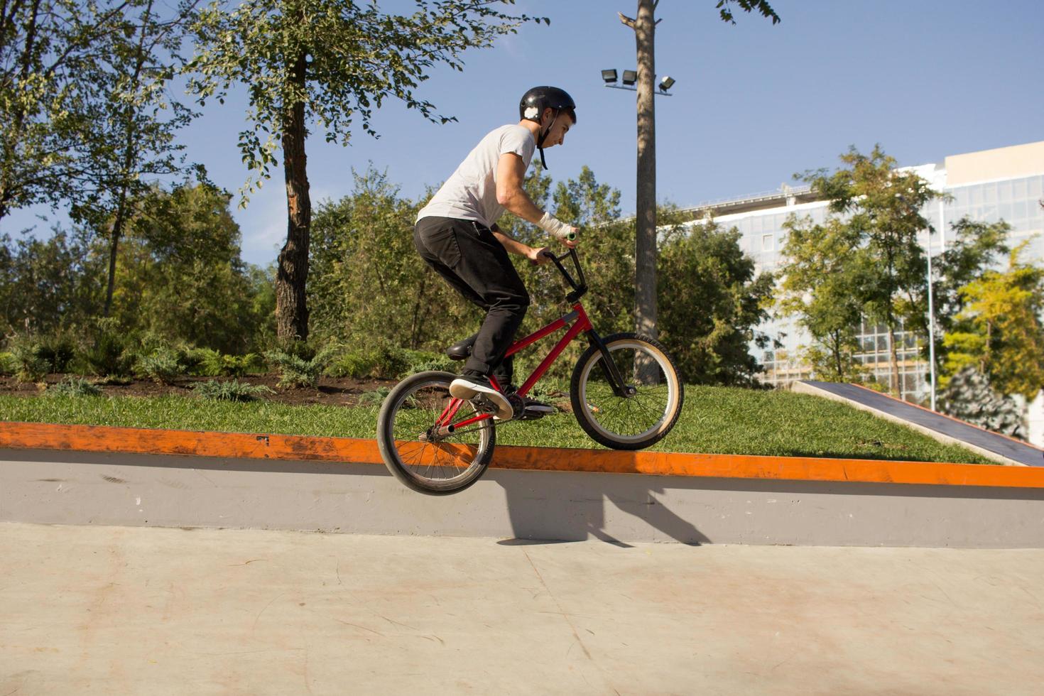 bmx rider che si allena e fa acrobazie in street plaza, bicyxle stunt rider in cocncrete skatepark foto