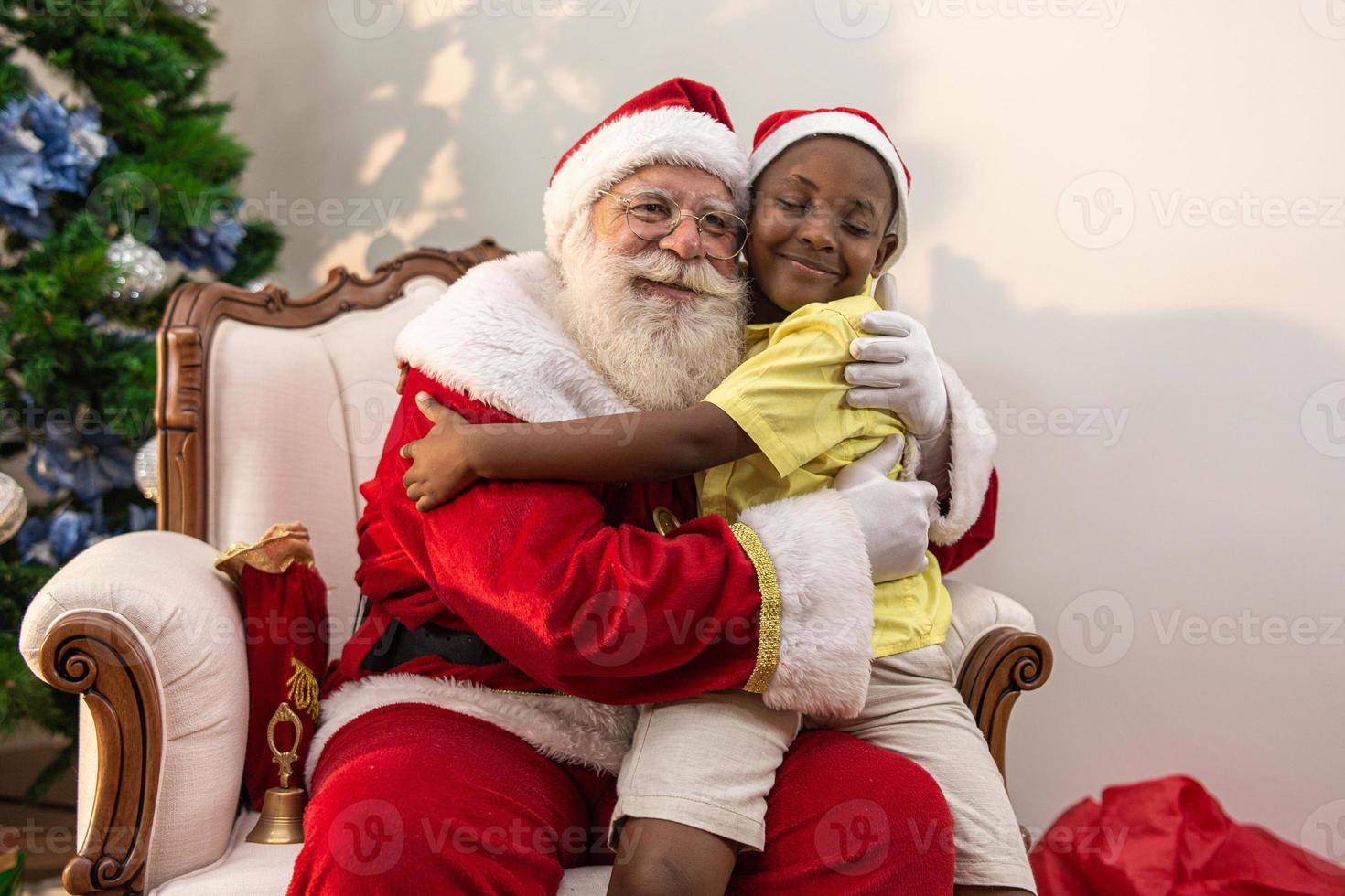 Babbo Natale consegna una confezione regalo a un ragazzino africano. abbraccio. vigilia di natale, consegna di regali. foto